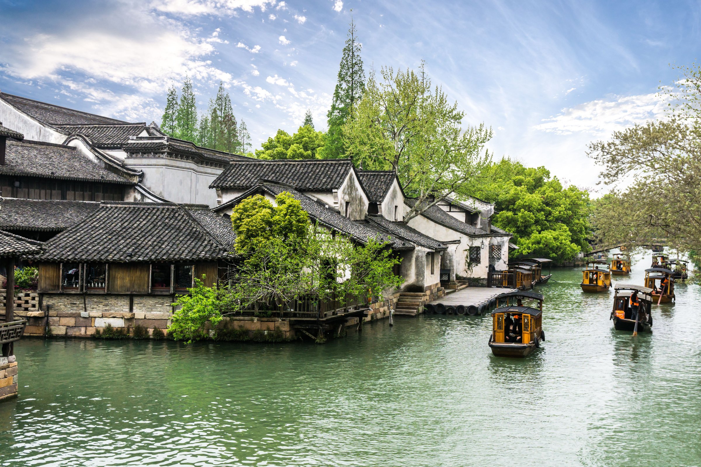 Kota air Wuzhen dengan kanal, perahu kayu tradisional, dan rumah berdinding putih beratap genteng