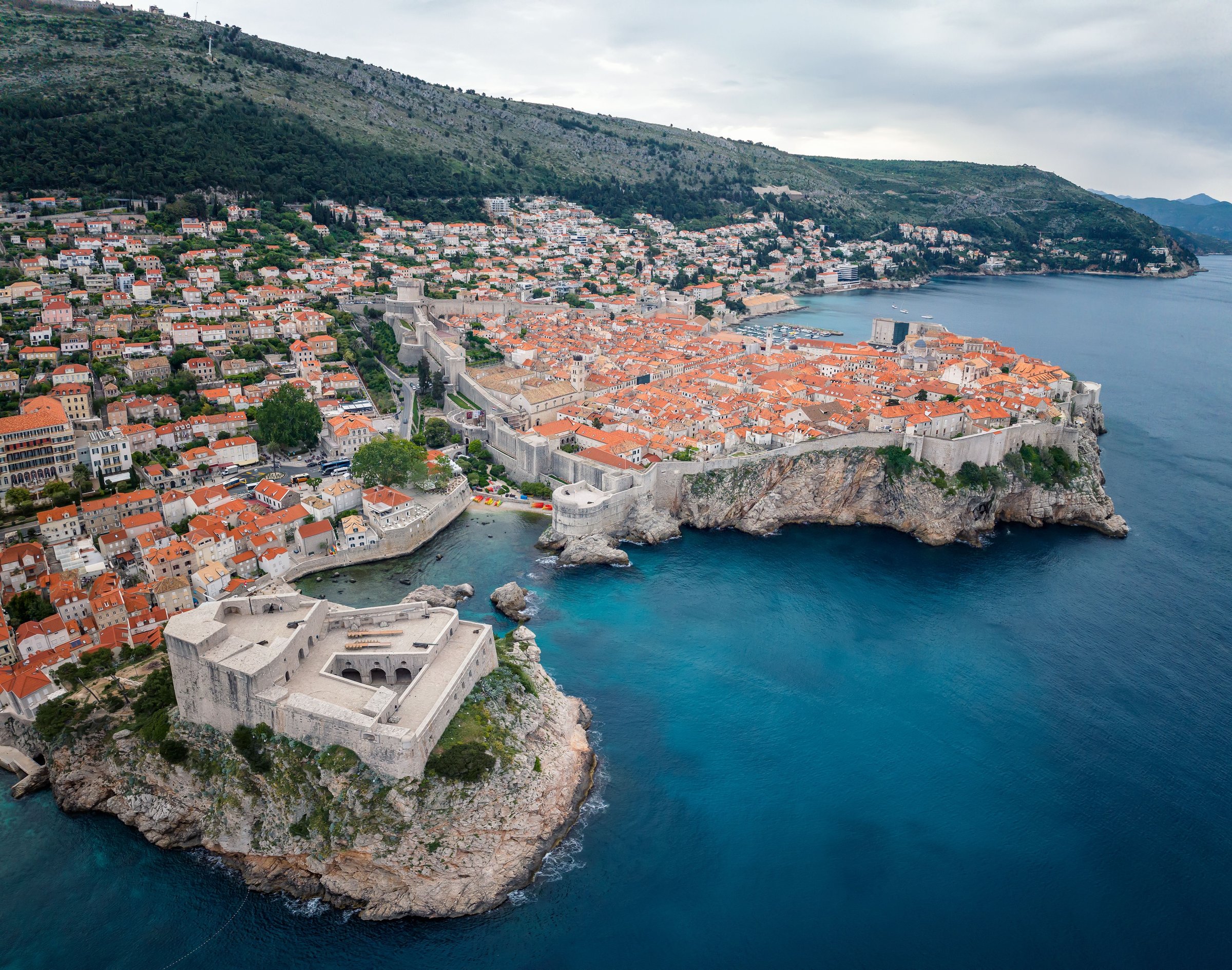 Tembok kota tua Dubrovnik dengan atap merah dan benteng batu di tepi laut Adriatik