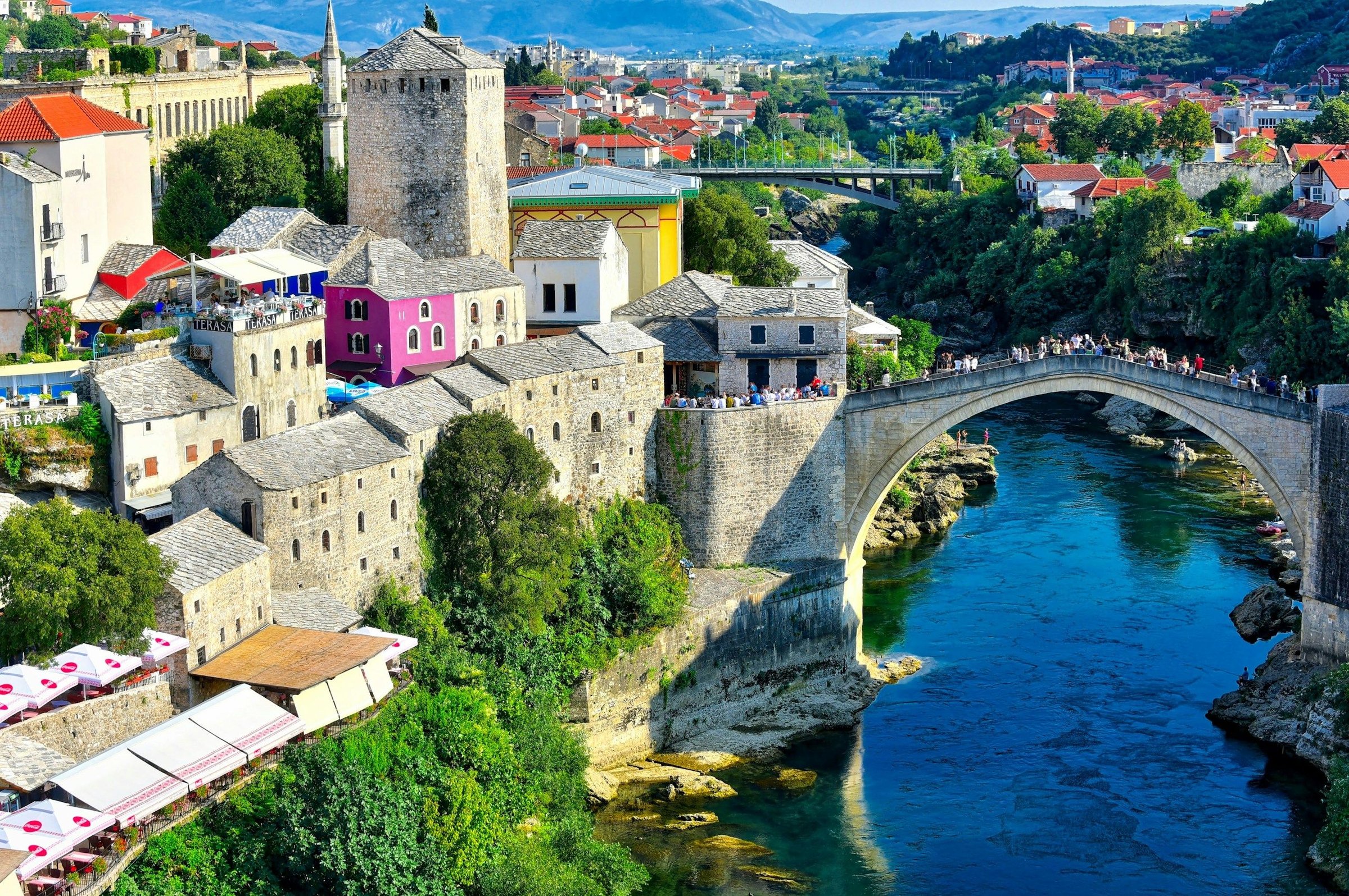 Jembatan Stari Most Mostar dengan sungai hijau-biru dan menara masjid