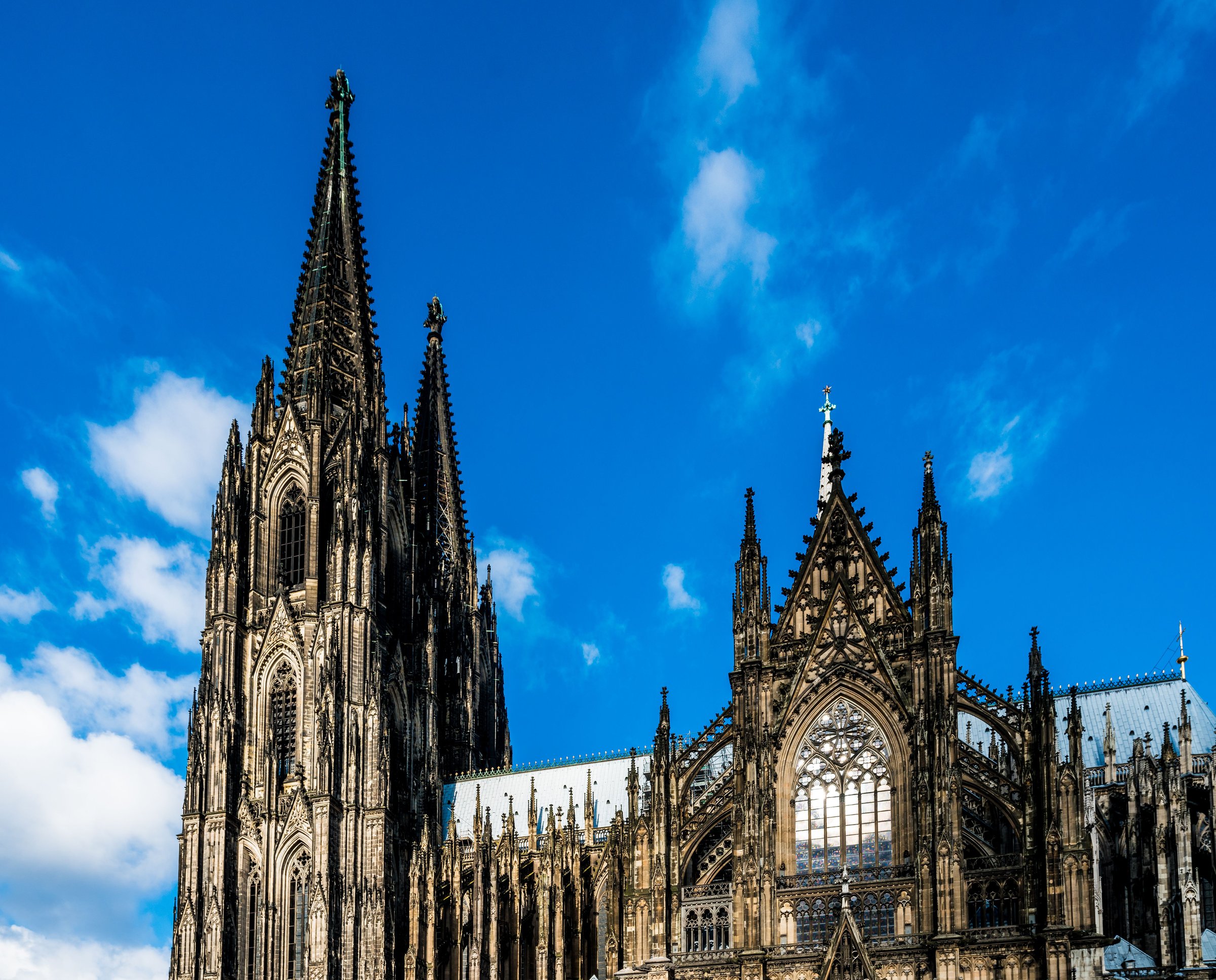 Menara kembar gotik Katedral Cologne menjulang di langit biru, situs warisan dunia UNESCO
