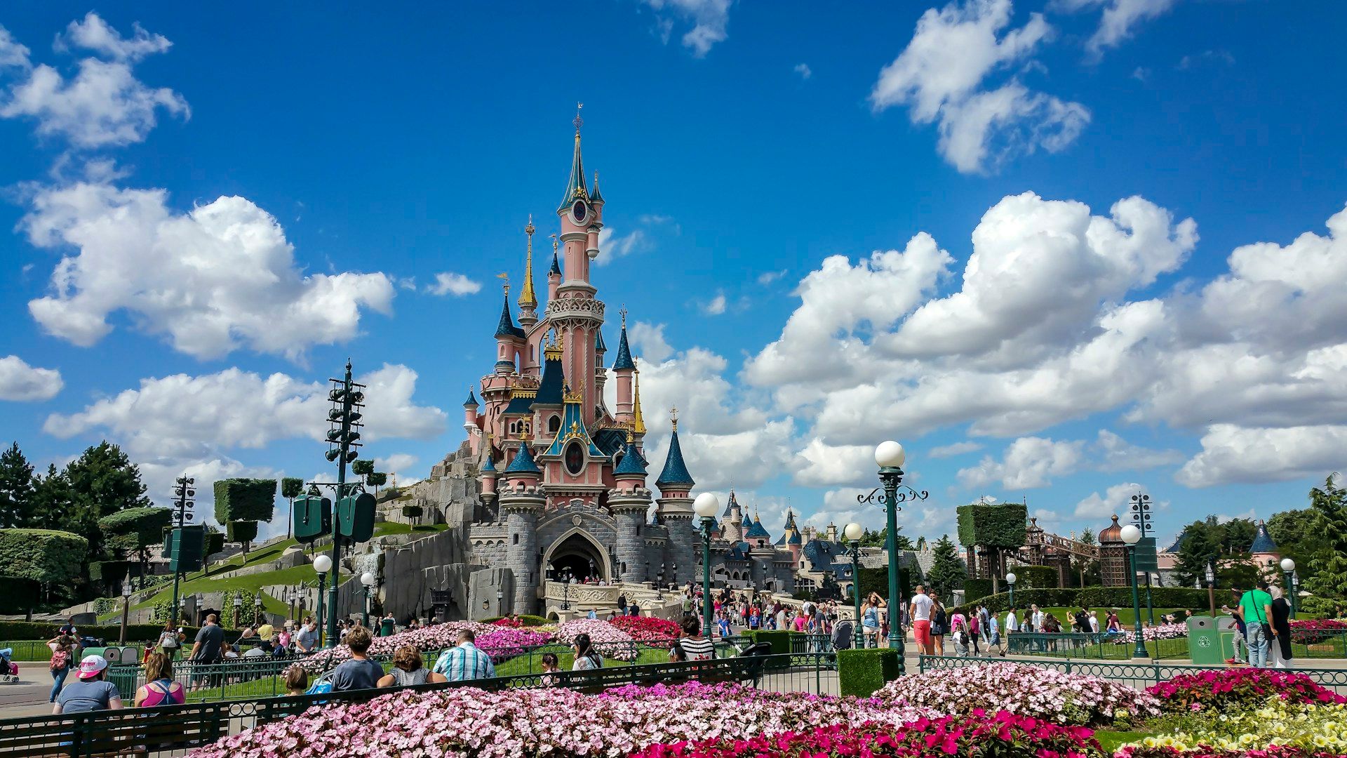Suasana taman Disneyland Paris dengan kastil dan taman bunga