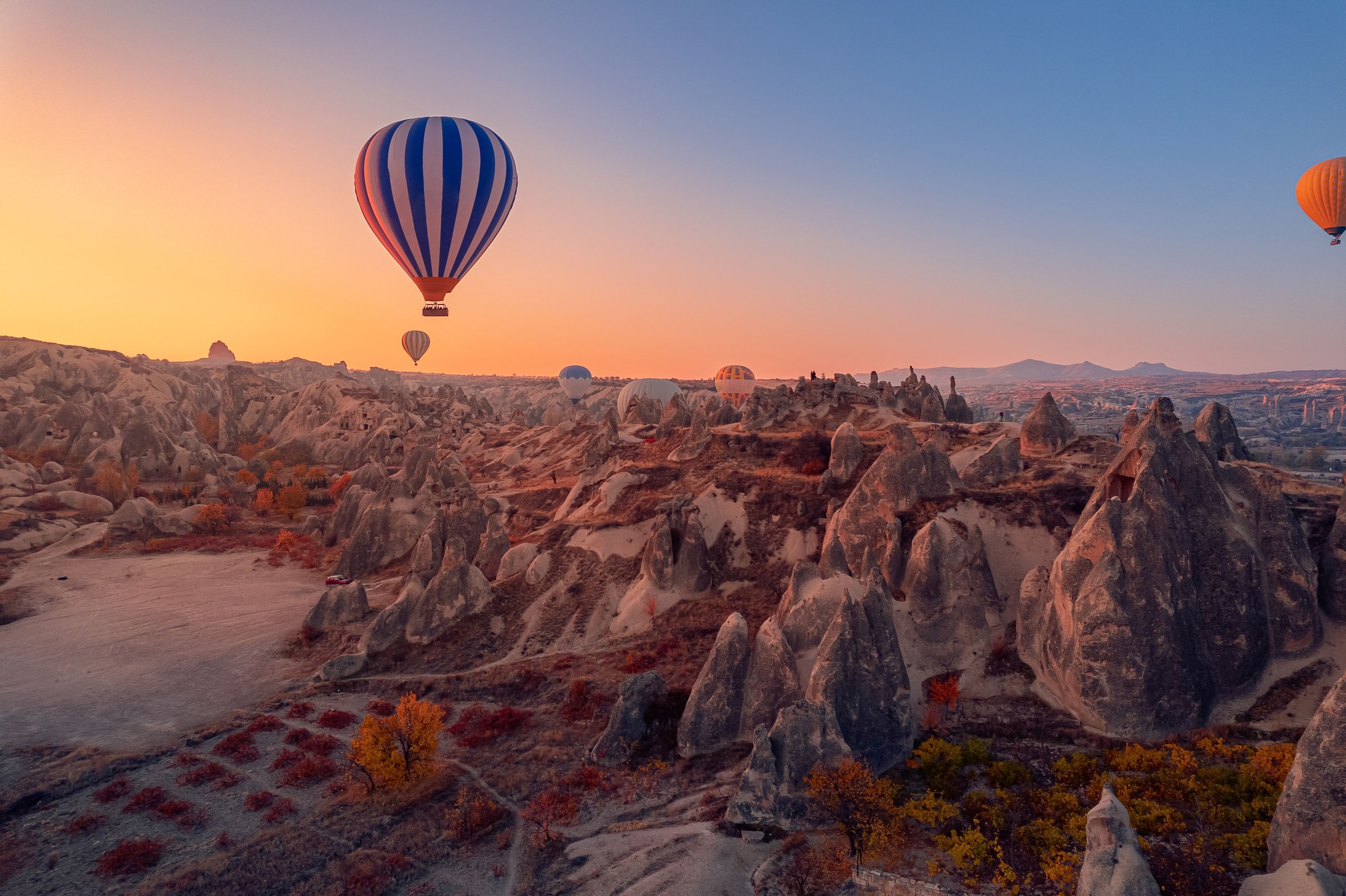Balon udara mengambang di atas lanskap batu Cappadocia saat matahari terbit