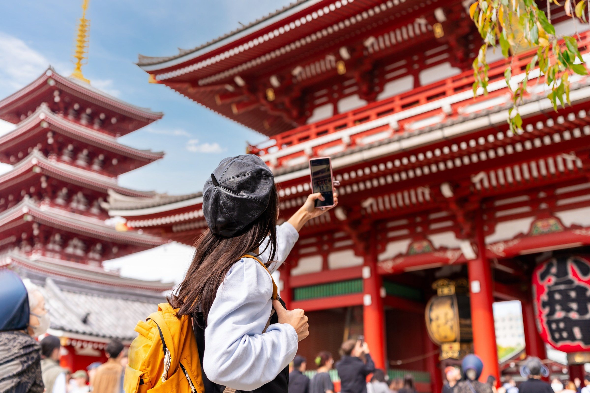 Perempuan memotret gerbang merah dan pagoda Sensoji di Asakusa saat siang cerah