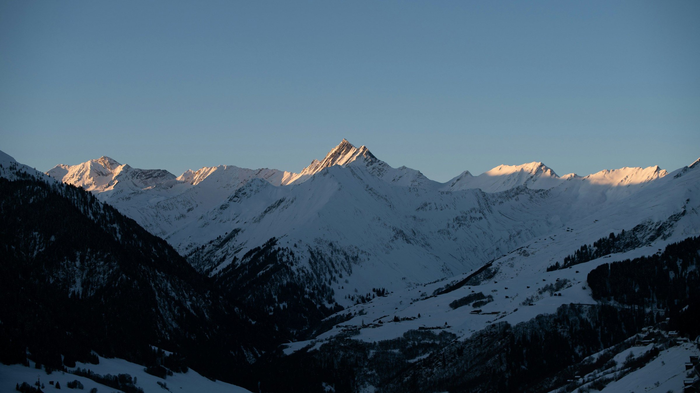 Puncak Pegunungan Alpen Swiss bersalju kena cahaya keemasan matahari terbit.