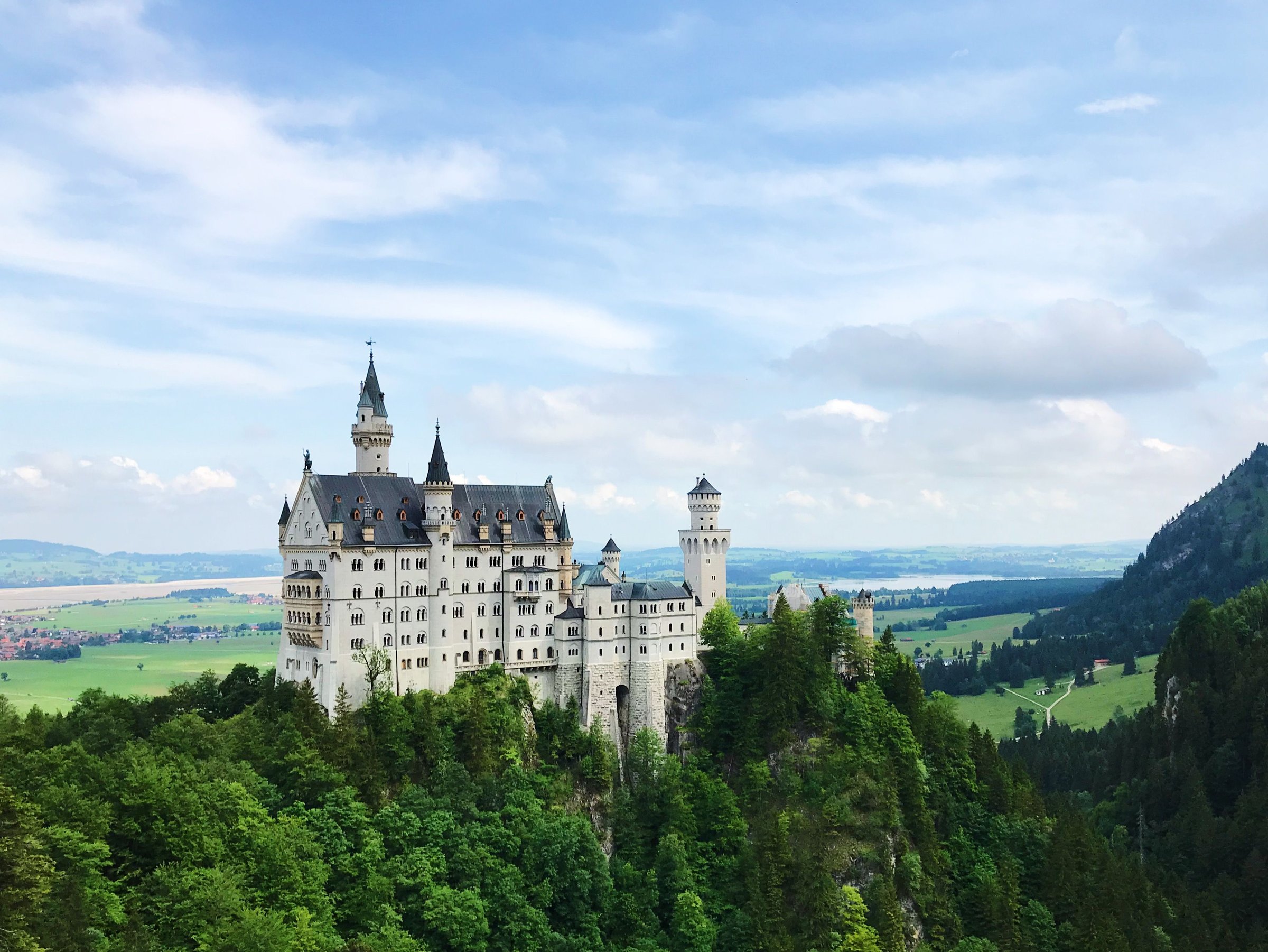 Kastil Neuschwanstein di Bavaria dikelilingi hutan di bawah langit cerah