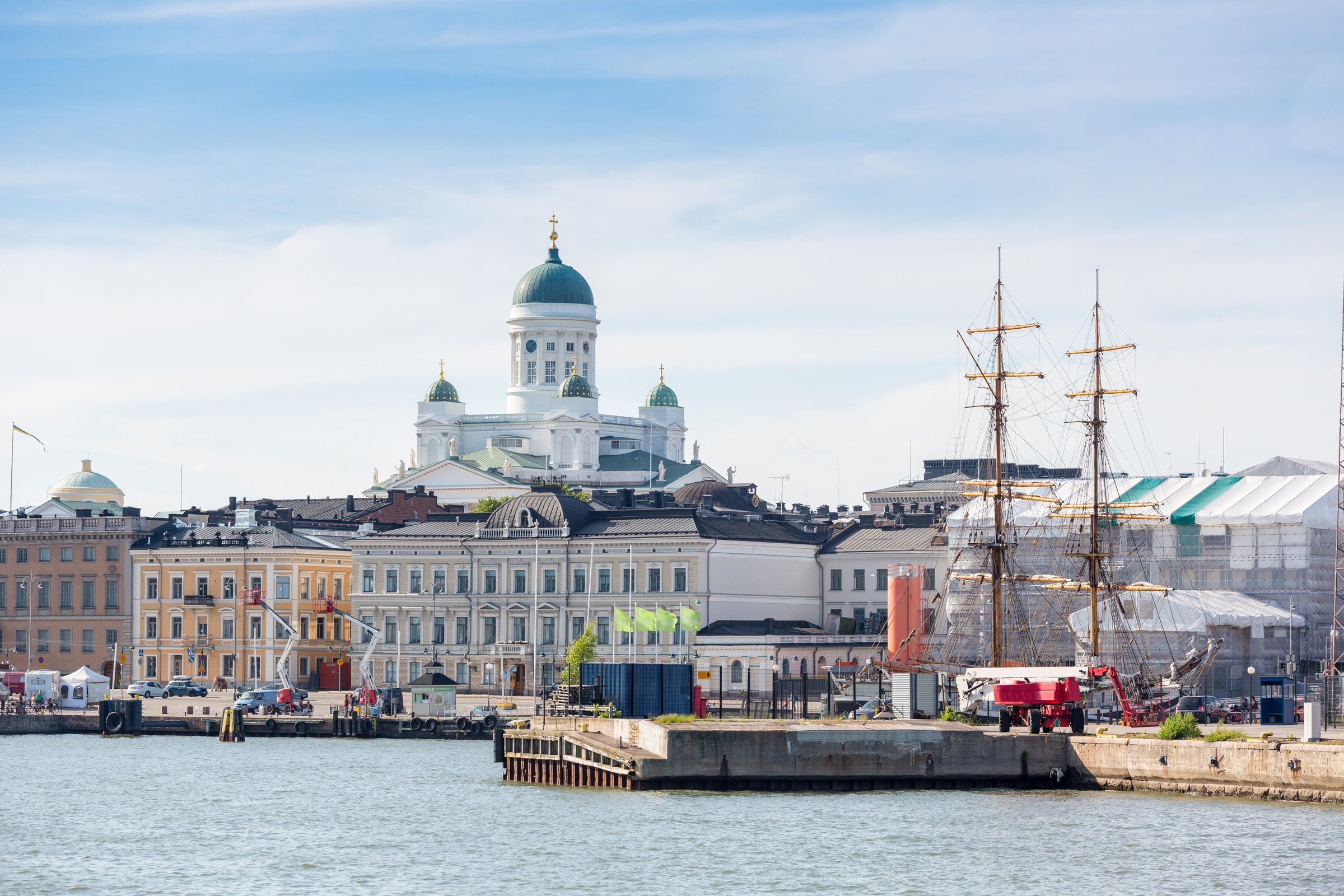 Kawasan pasar di tepi pelabuhan Helsinki dengan kapal bersandar dan katedral di kejauhan