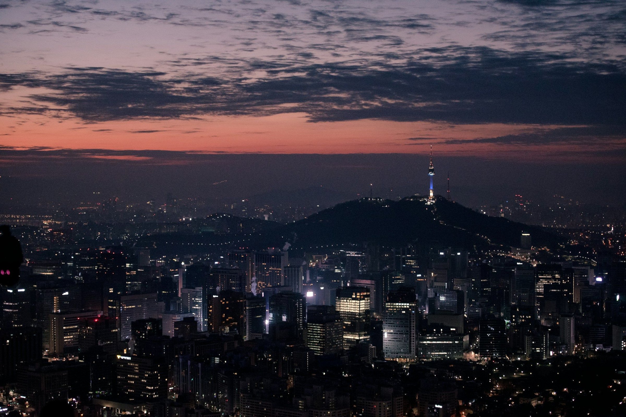 Panorama kota Seoul saat senja dengan N Seoul Tower di puncak Namsan
