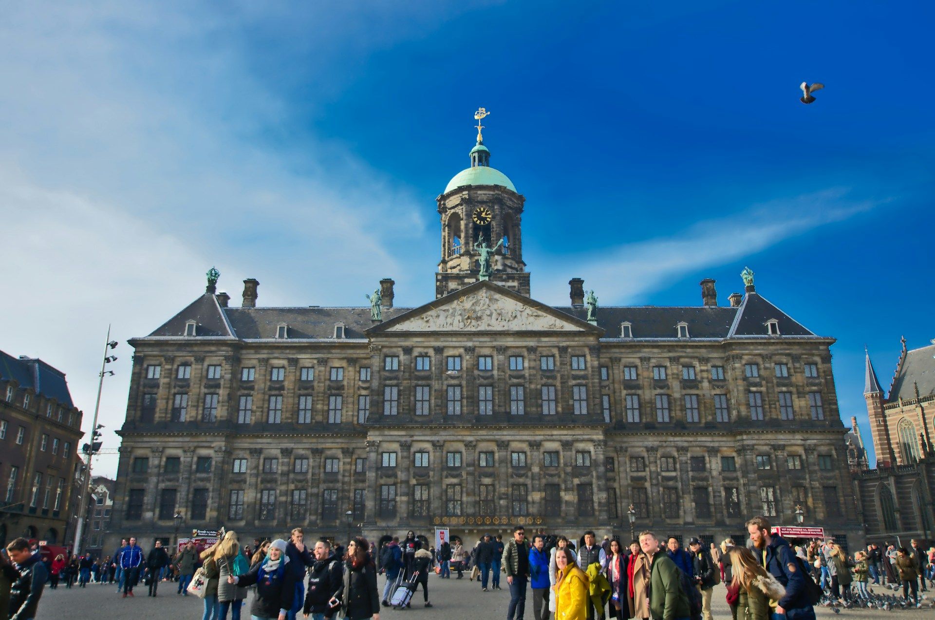 Royal Palace Amsterdam di Dam Square dengan pengunjung di depannya