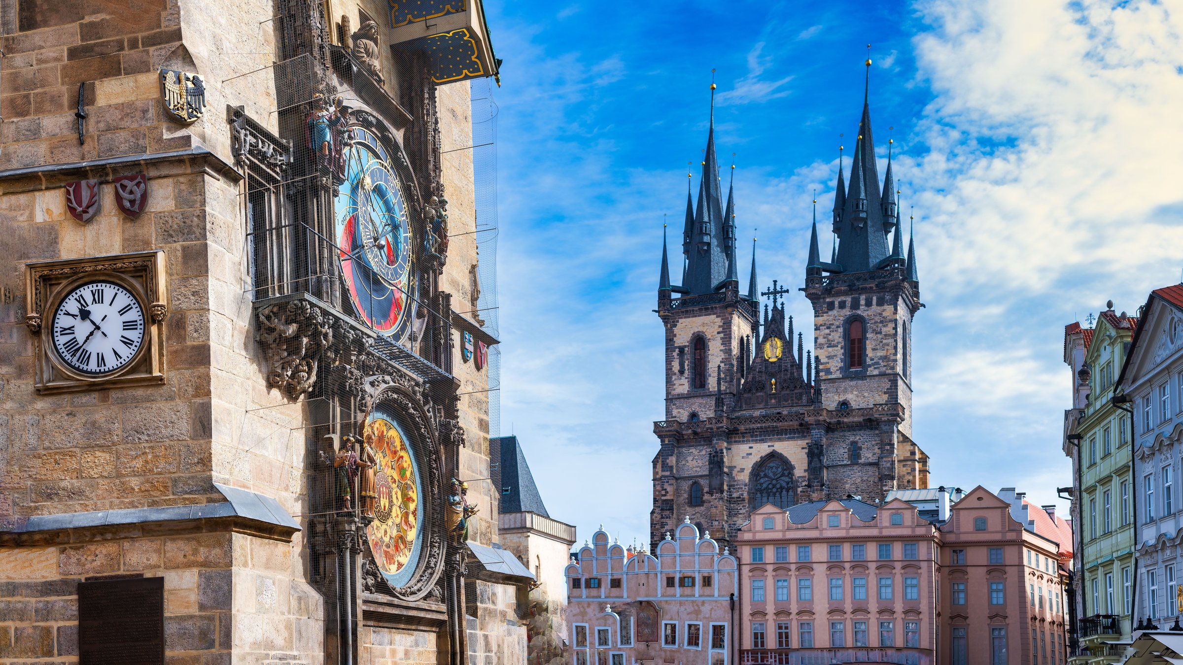 Jam astronomis Praha di Old Town Square dengan menara Gereja Tyn di kejauhan