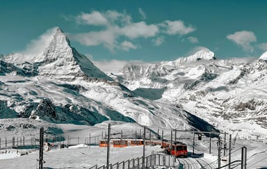 Puncak Matterhorn bersalju di Pegunungan Alpen Swiss dengan kereta Gornergrat merah melintas di Zermatt, Swiss