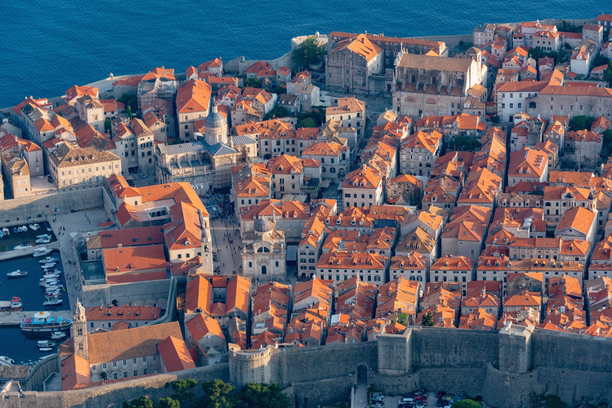Foto udara Kota Tua Dubrovnik, Kroasia, dengan atap oranye dan tembok kota di tepi Laut Adriatik