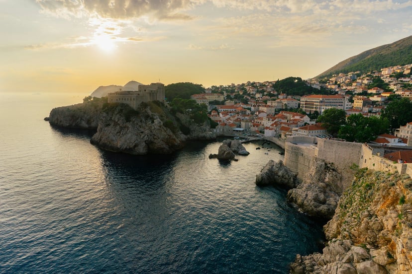Alun-alun batu kota tua Dubrovnik dengan air mancur berkubah dan atap terakota di sekelilingnya.