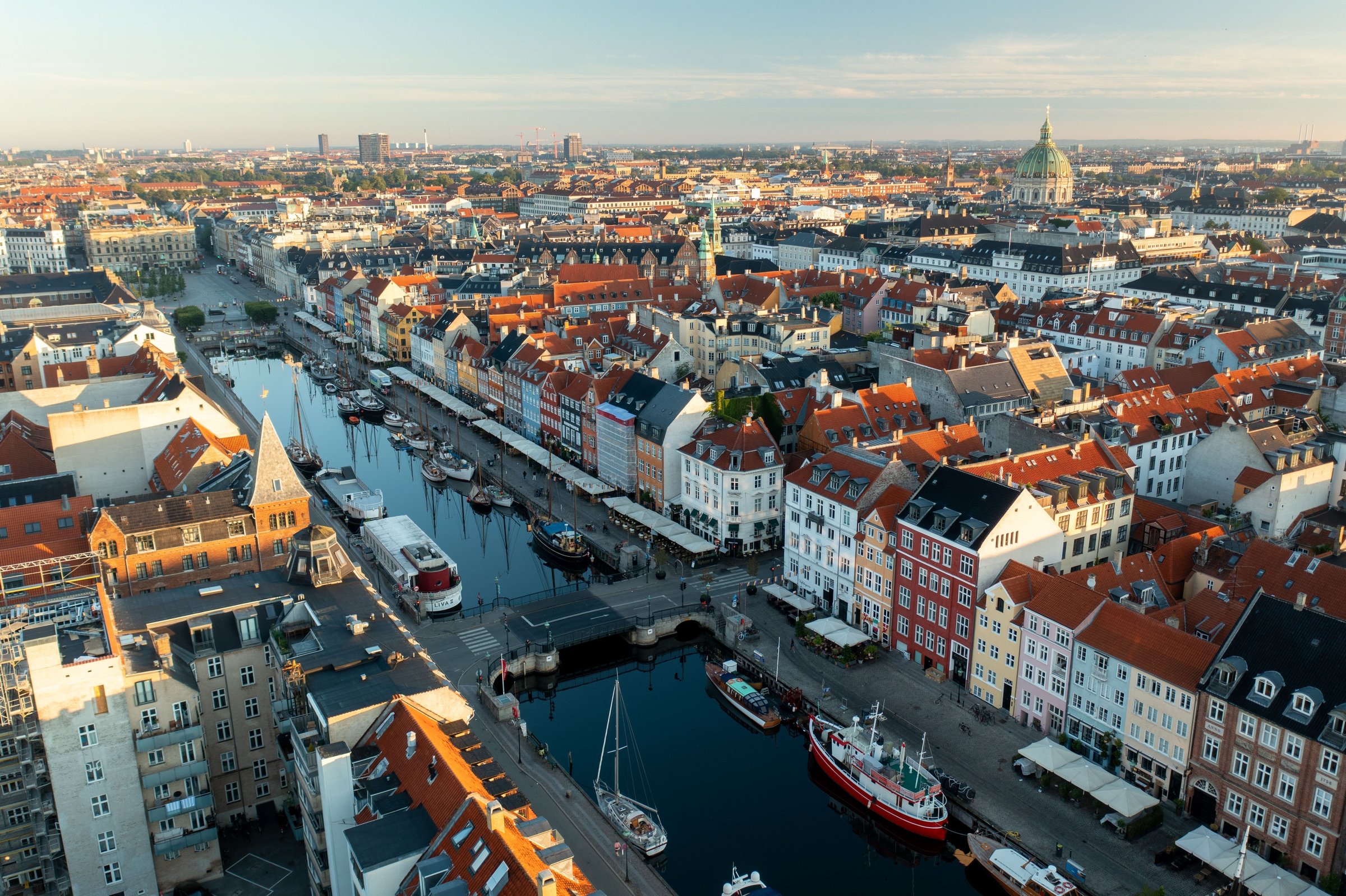 Deretan bangunan warna-warni tepi kanal Nyhavn dilihat dari udara dengan atap merah Copenhagen