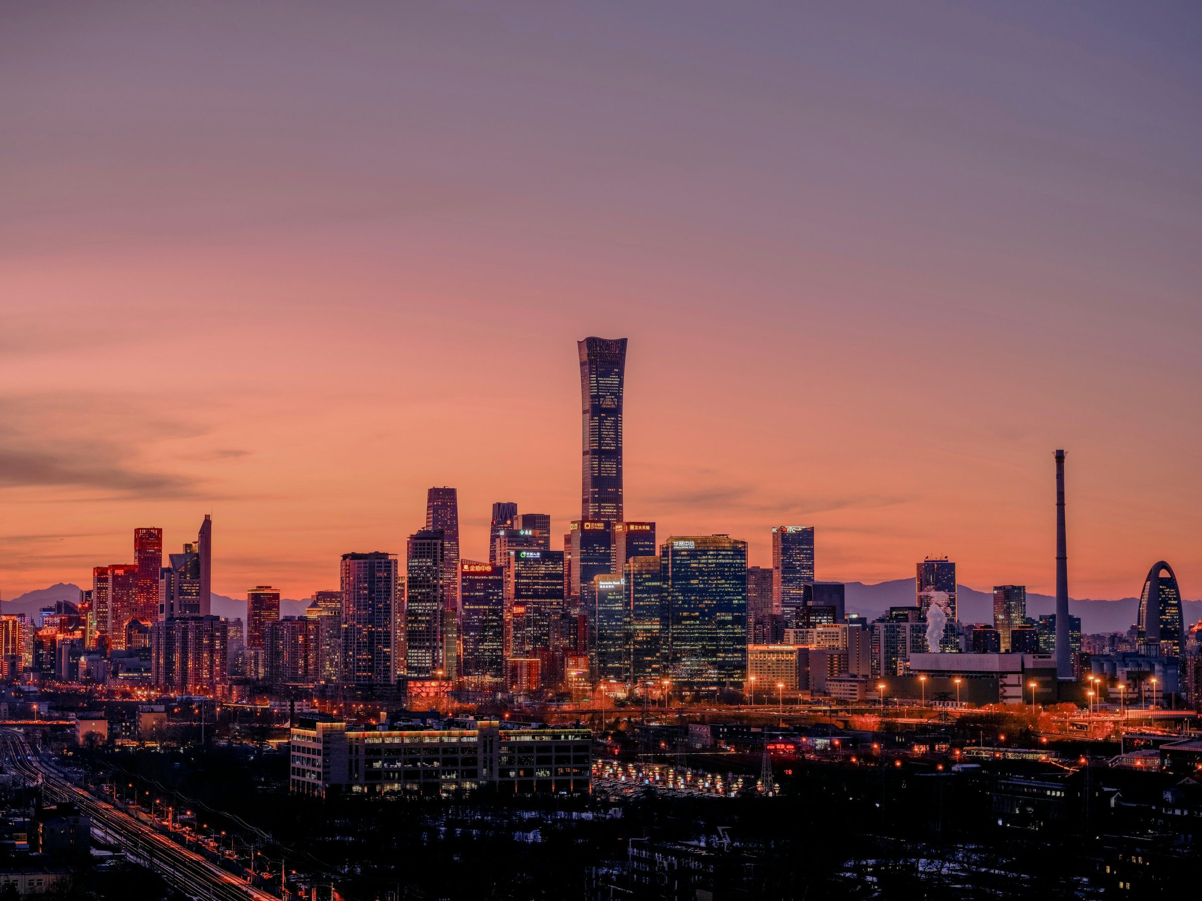 Panorama Beijing saat matahari terbit dengan siluet kota di kejauhan.