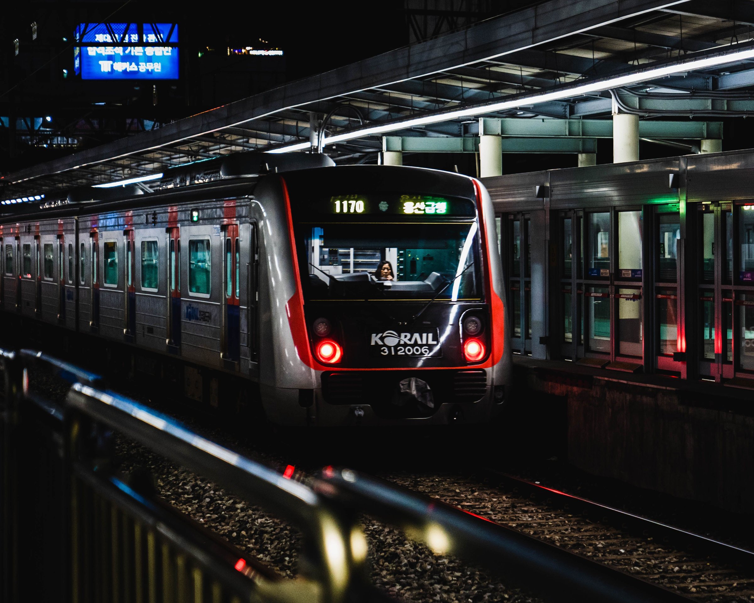 Kereta Korail berlampu merah menyala tiba di stasiun Seoul pada malam hari
