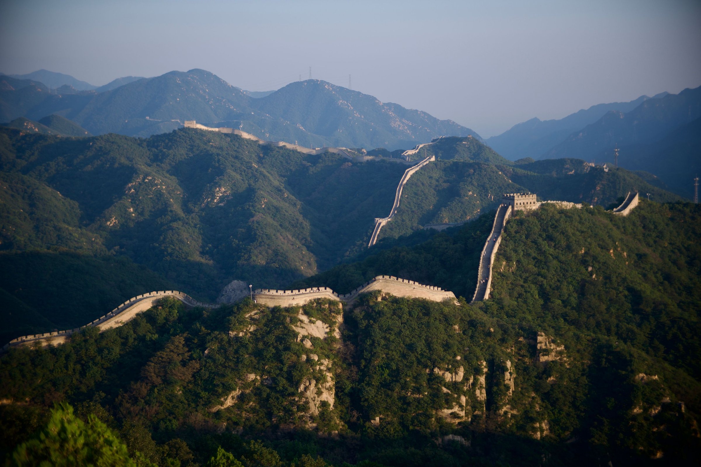 Great Wall of China membentang di punggung gunung hijau