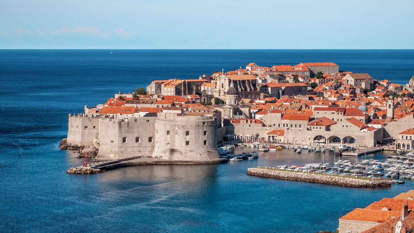 Tembok kota tua Dubrovnik dengan atap merah khas dan laut Adriatik di latar
