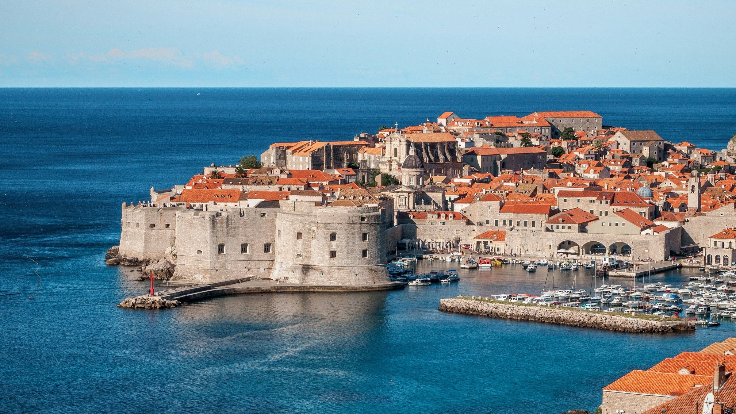 Kota tua Dubrovnik dengan tembok benteng batu, atap merah khas, dan Laut Adriatik biru di Kroasia