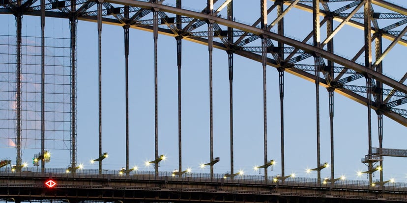 Jembatan Sydney Harbour dan atap Opera House dalam satu bingkai vertikal di bawah langit biru