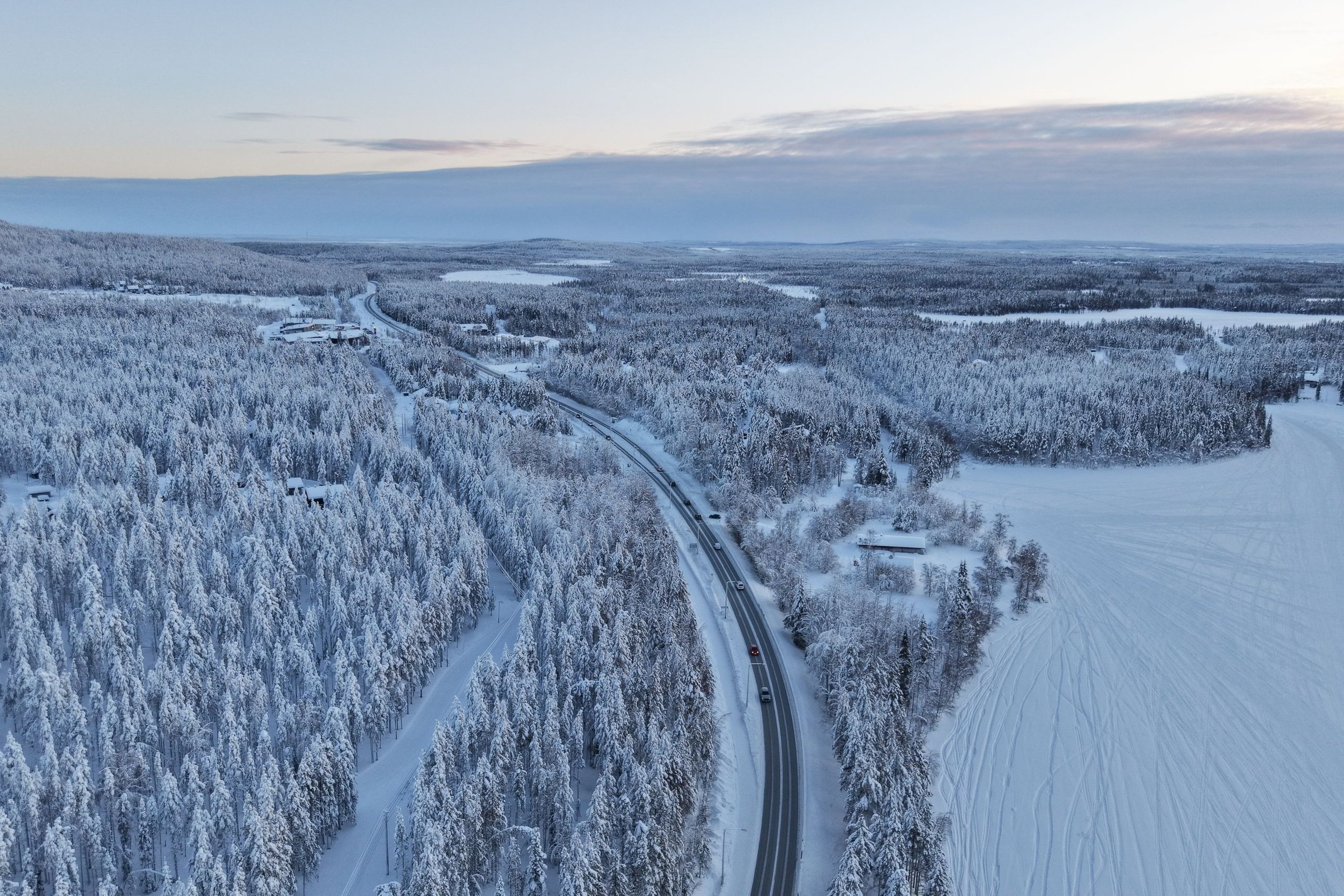 Jalan Arktik berkelok menembus hutan bersalju Lapland dari udara.