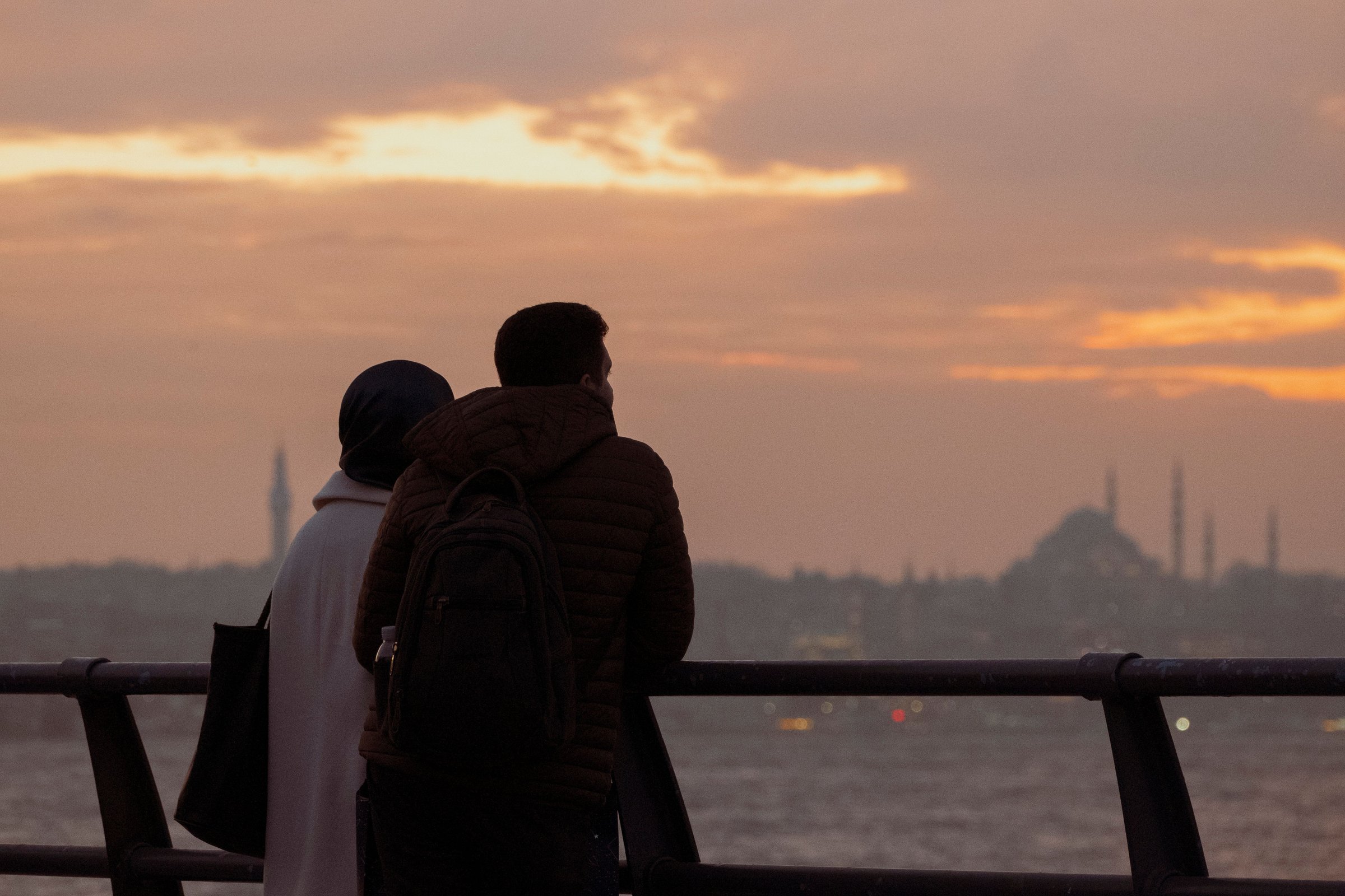 Pasangan siluet menghadap Bosphorus Istanbul saat senja keemasan