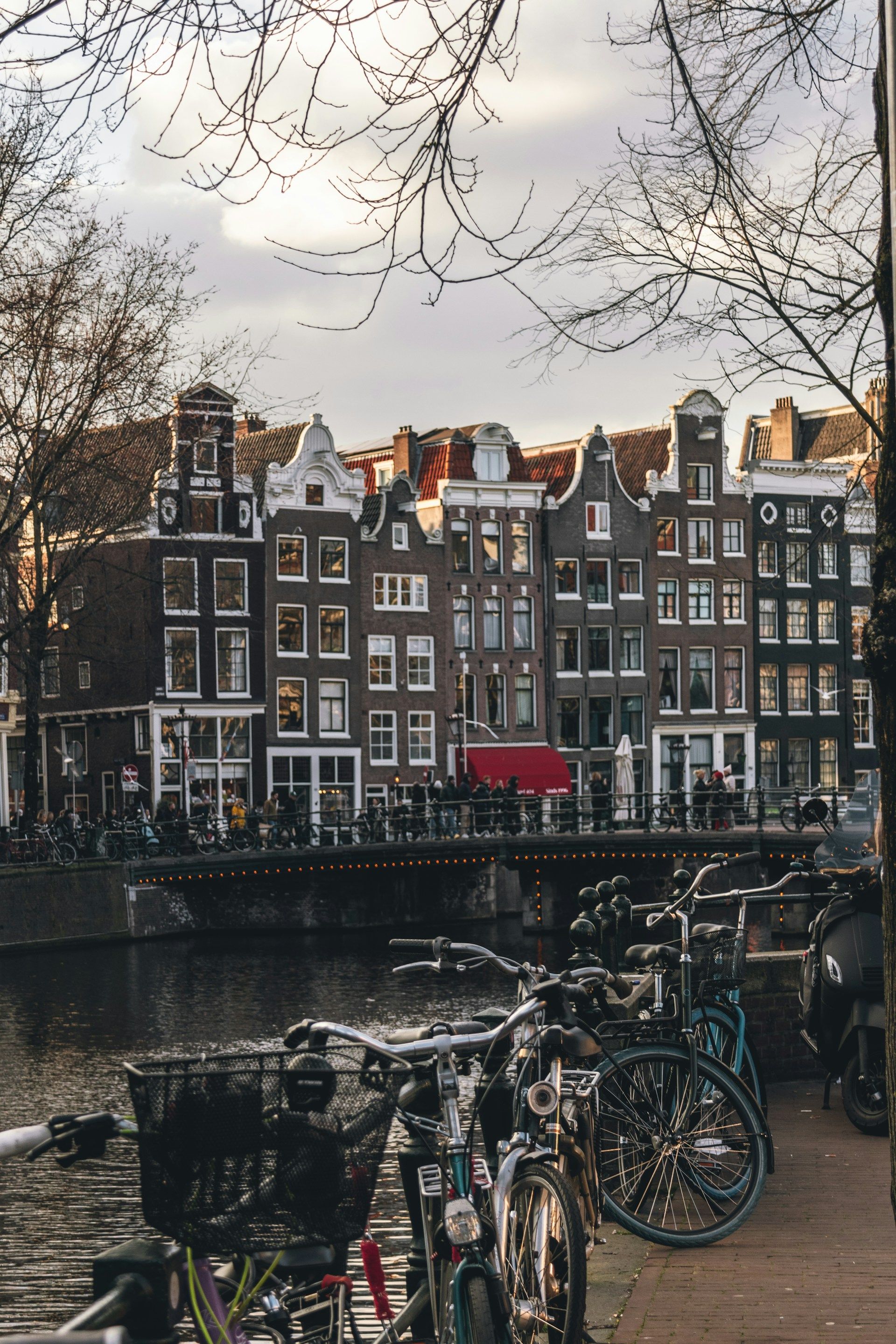 Rumah kanal khas Amsterdam dengan jembatan dan sepeda, Belanda