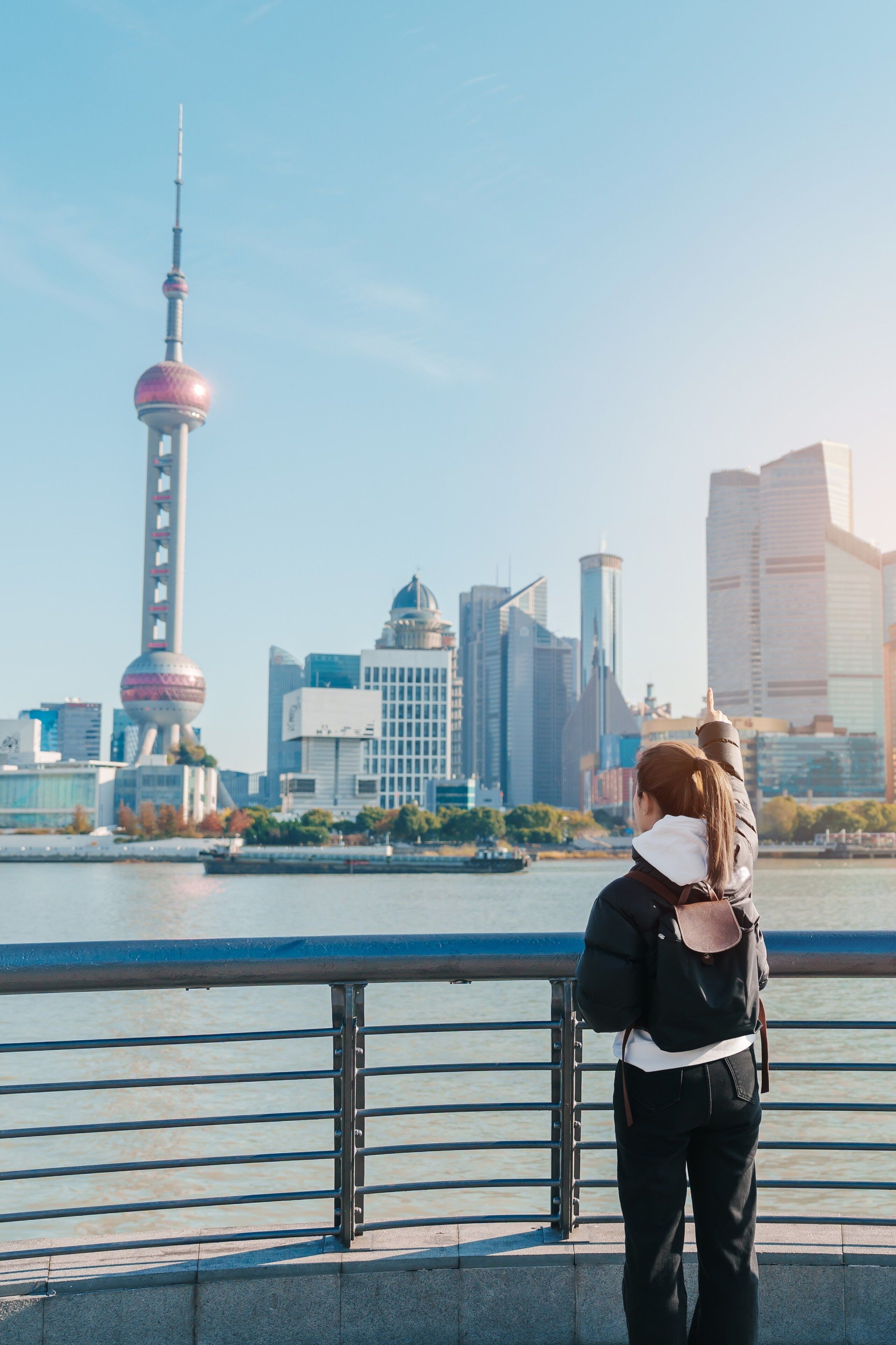 Perempuan memandang skyline Pudong dari tepi sungai di The Bund, Shanghai