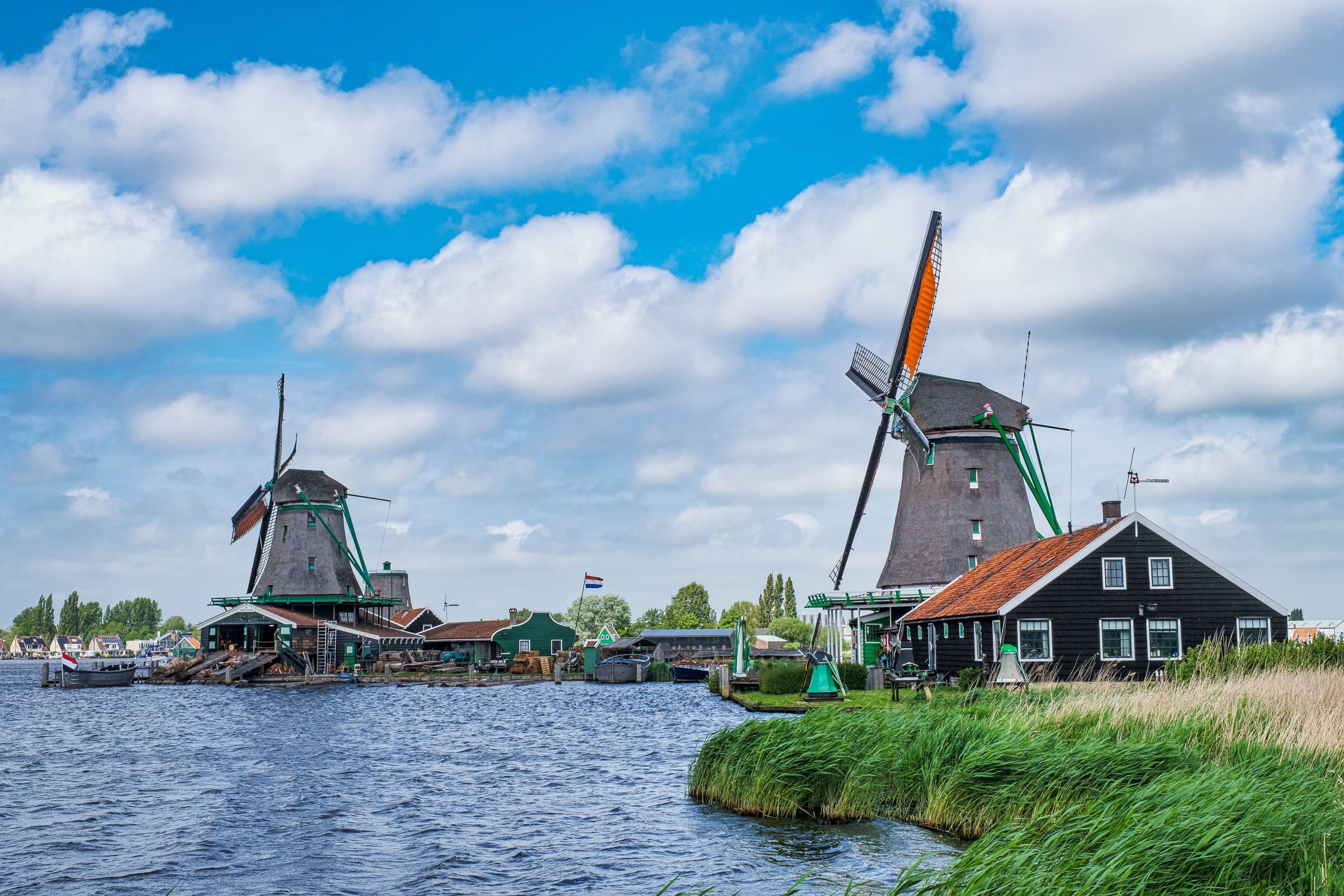 Deretan kincir angin tua Zaanse Schans berdiri di tepi air, Belanda