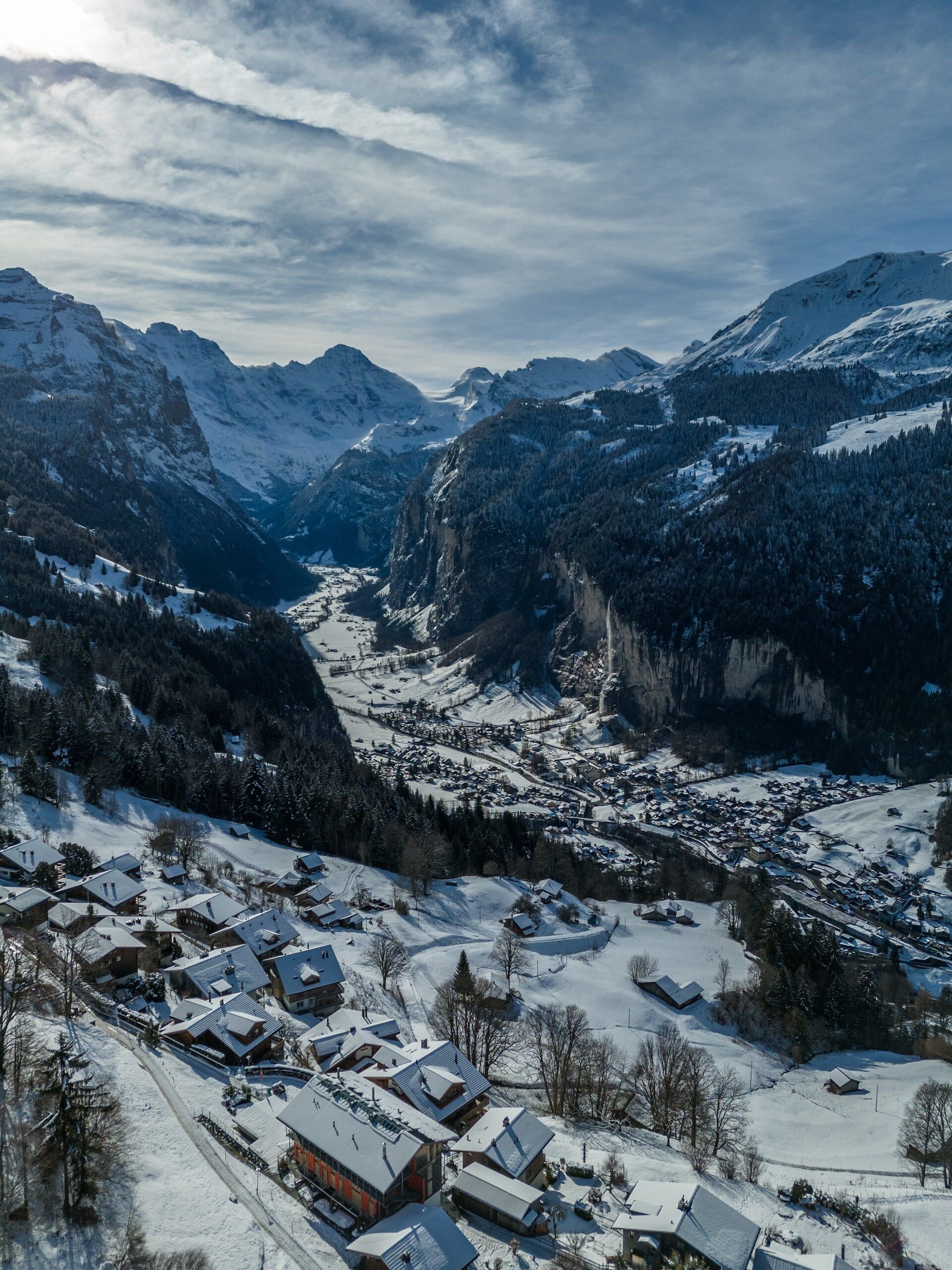 Desa Lauterbrunnen dan atap bersalju dari udara, lembah dan pegunungan Alpen di belakangnya.