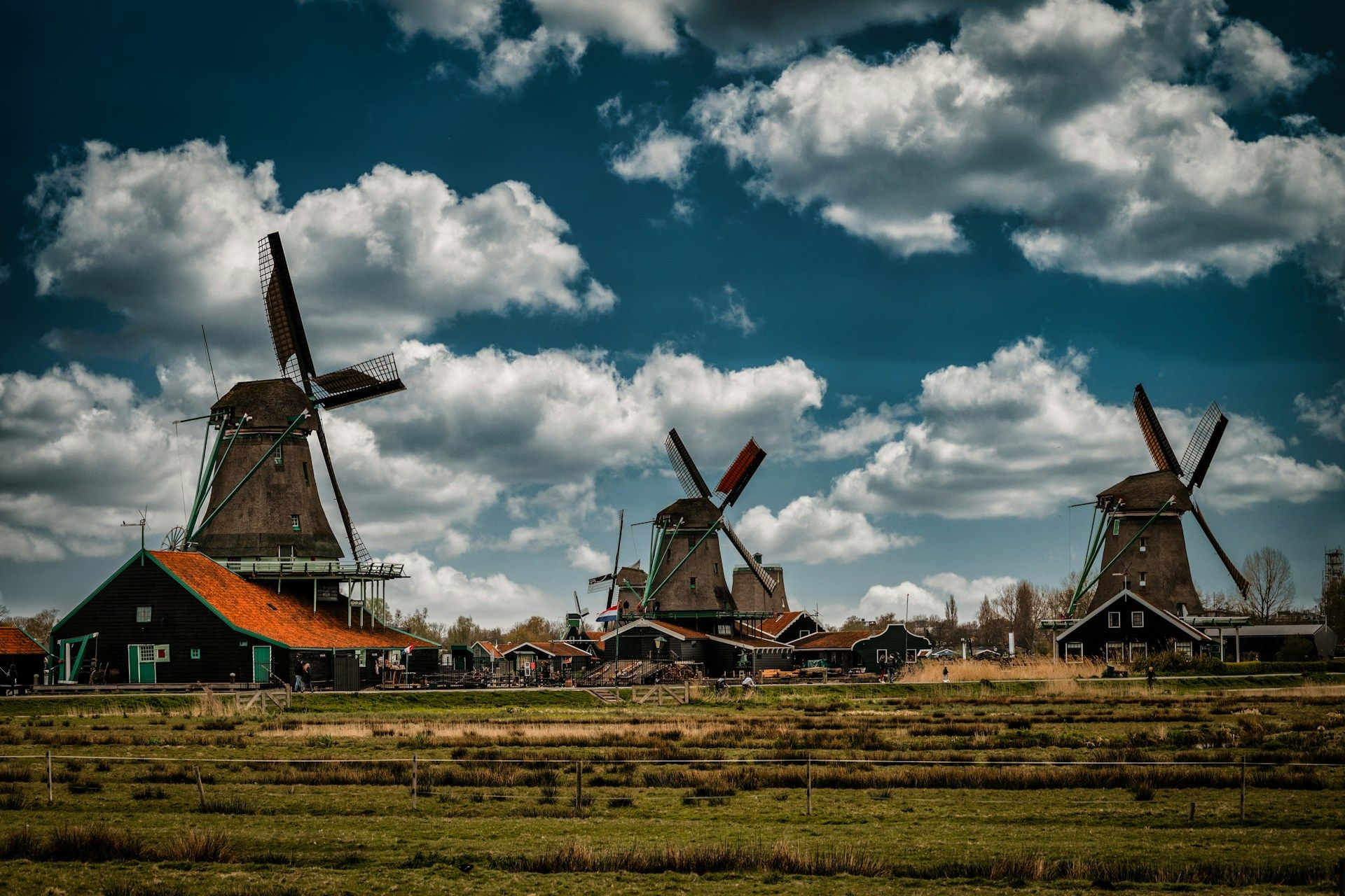 Kincir angin Zaanse Schans di padang hijau dengan langit berawan, Belanda