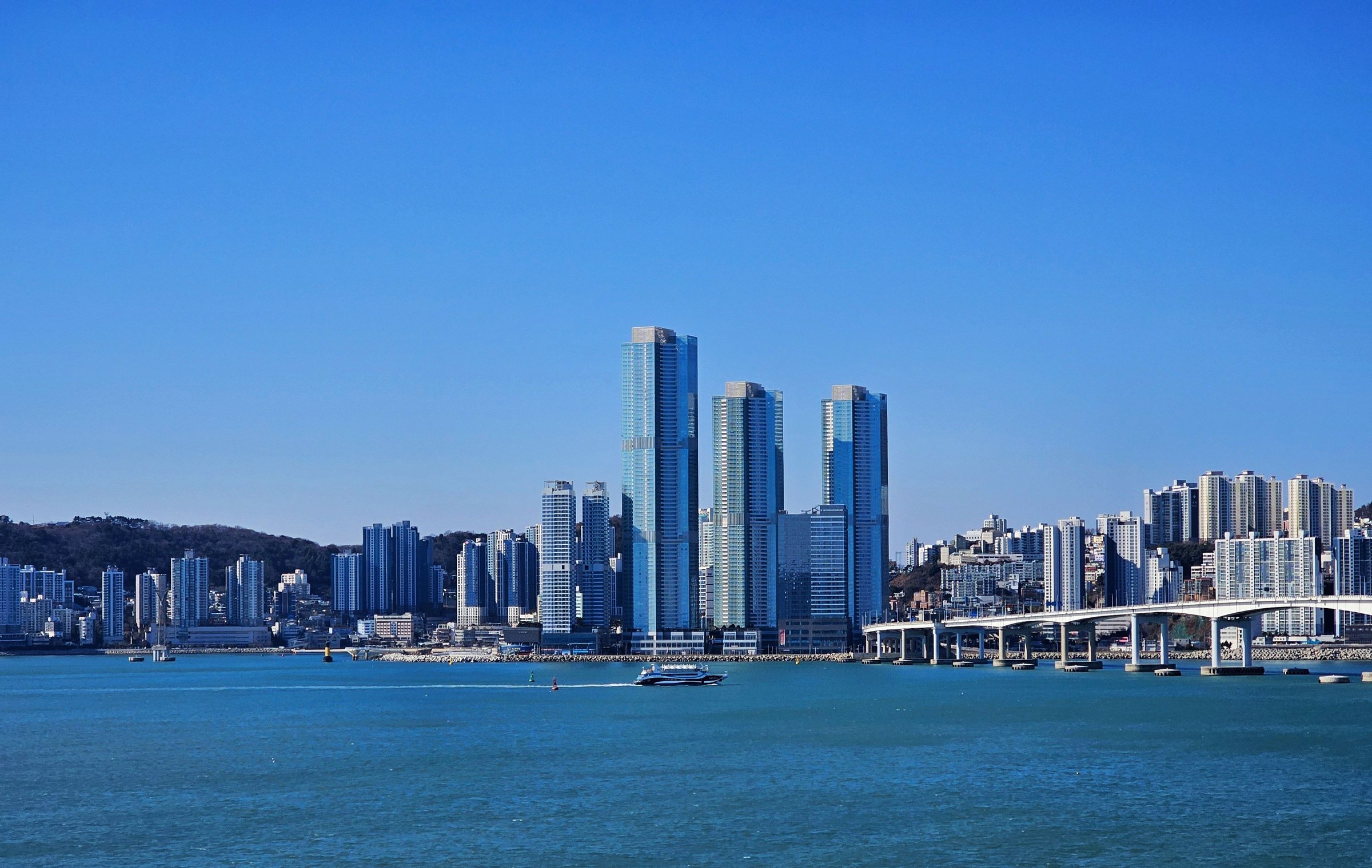 Gedung pencakar langit Marine City Busan menjulang di tepi laut biru cerah