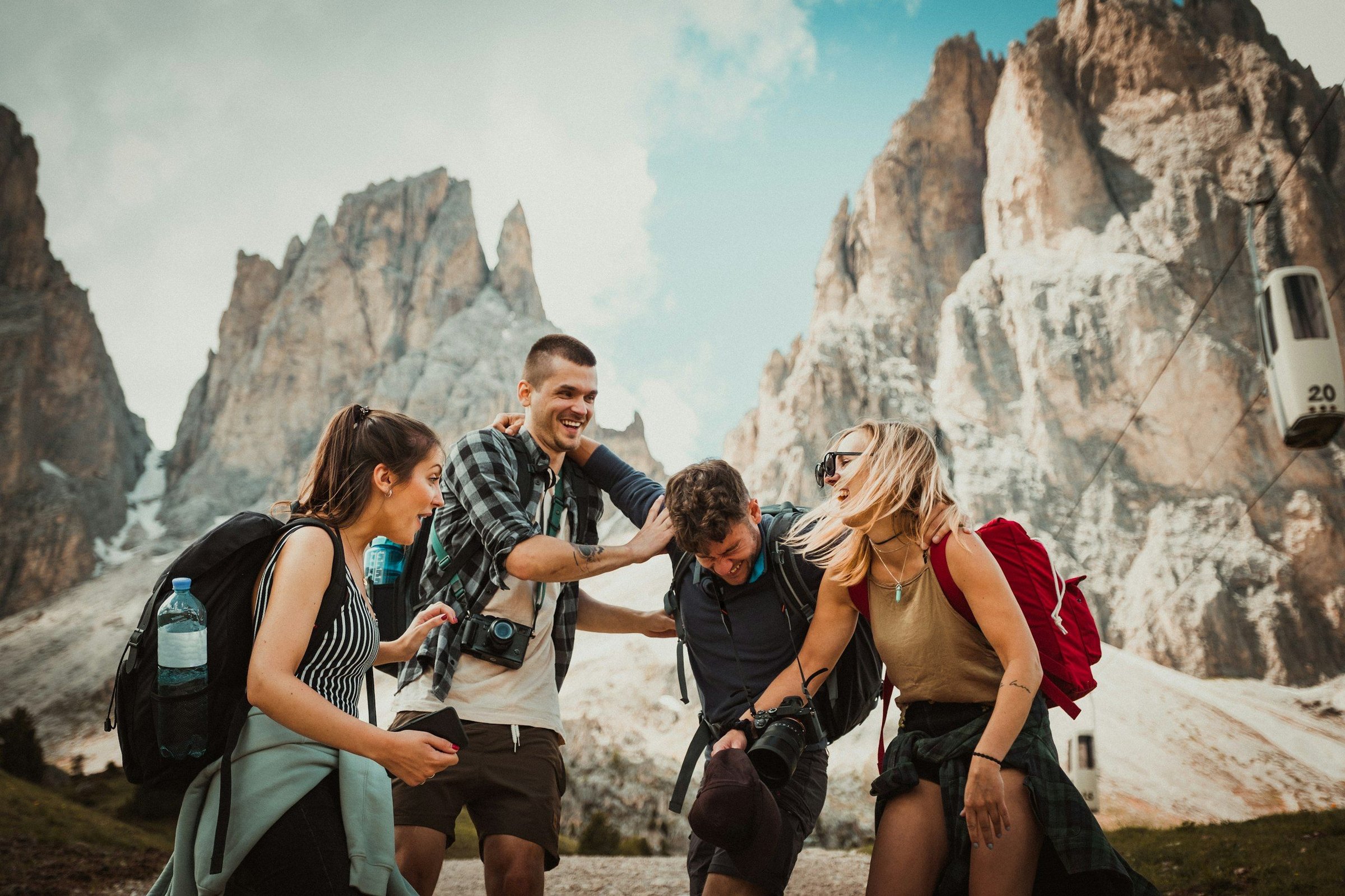 Sekelompok kecil empat wisatawan tertawa bersama di pegunungan Dolomites Italia