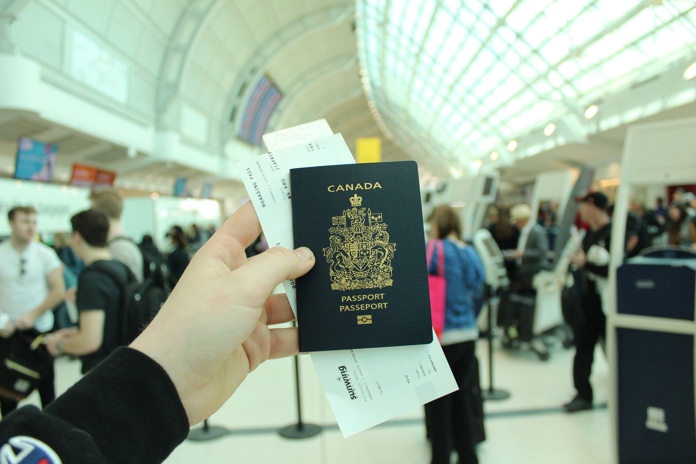 Tangan memegang paspor dan boarding pass di terminal bandara internasional