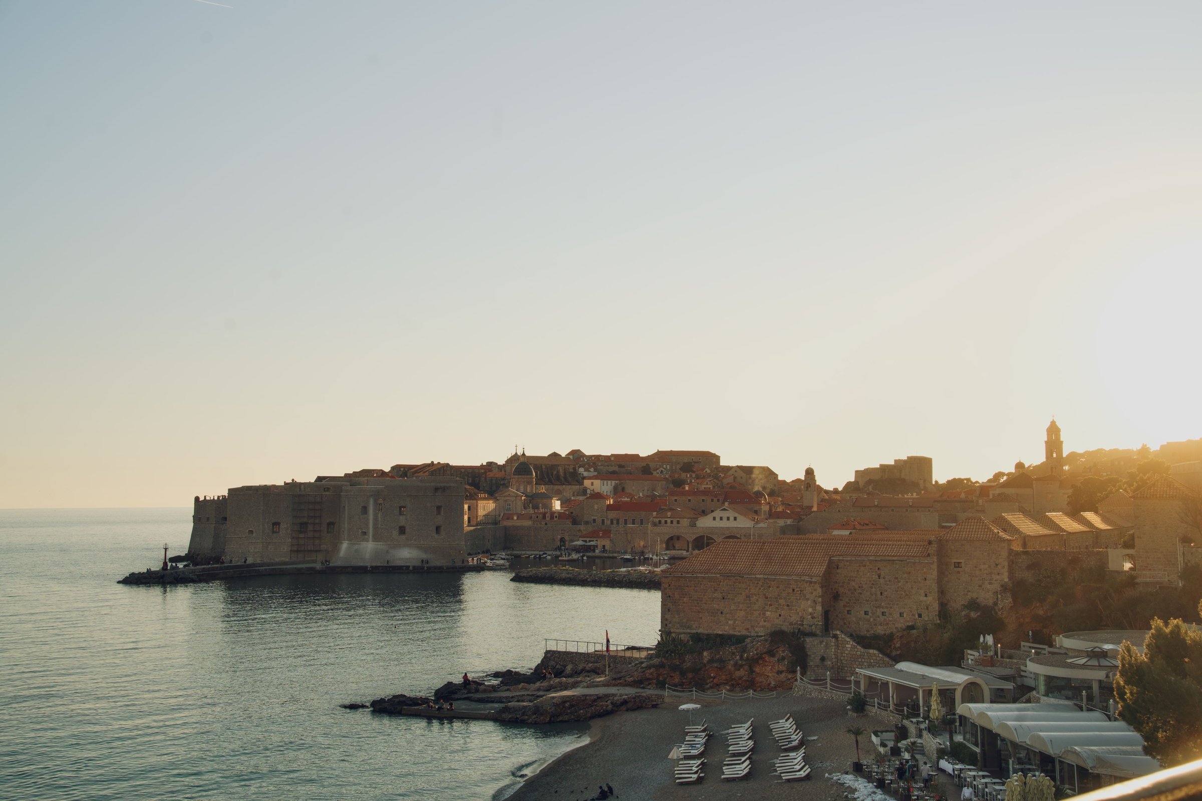 Kota Tua Dubrovnik, Kroasia, saat matahari terbenam dengan pantai di tepi laut