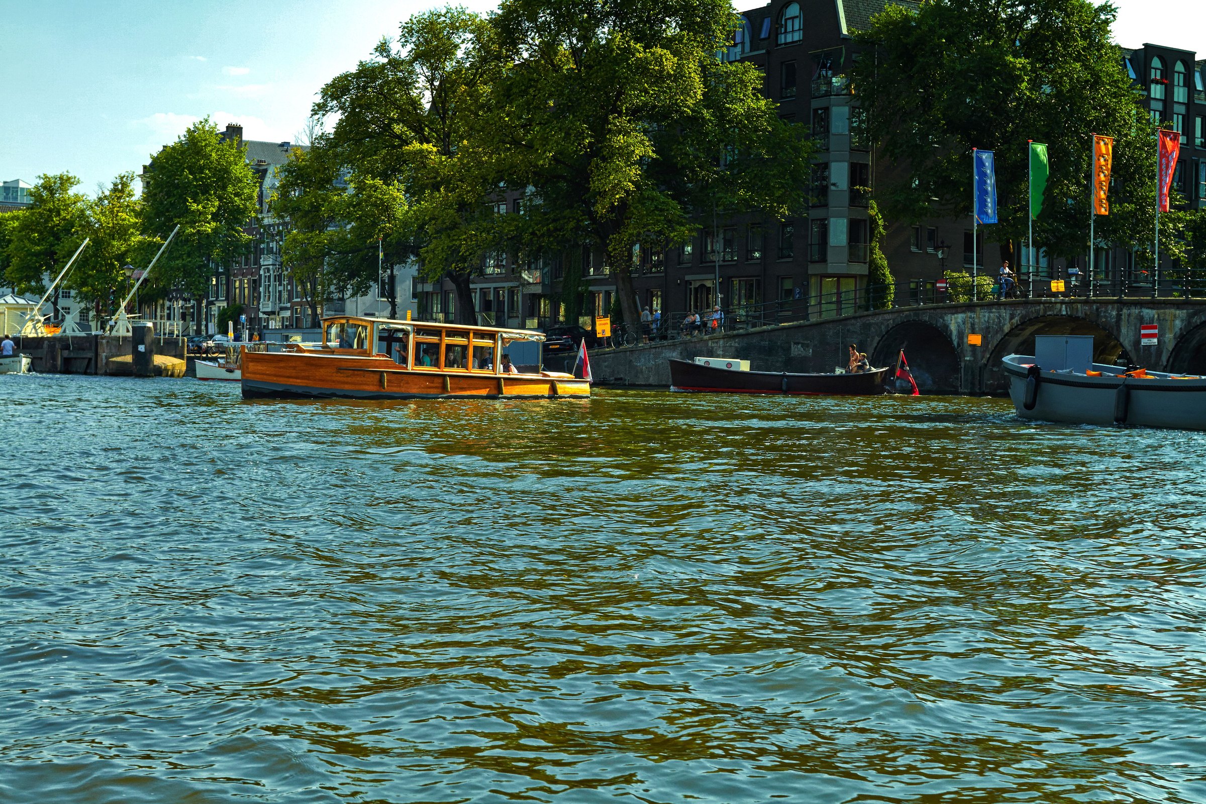Kanal Amsterdam dengan deretan rumah tua dan perahu di sore hari