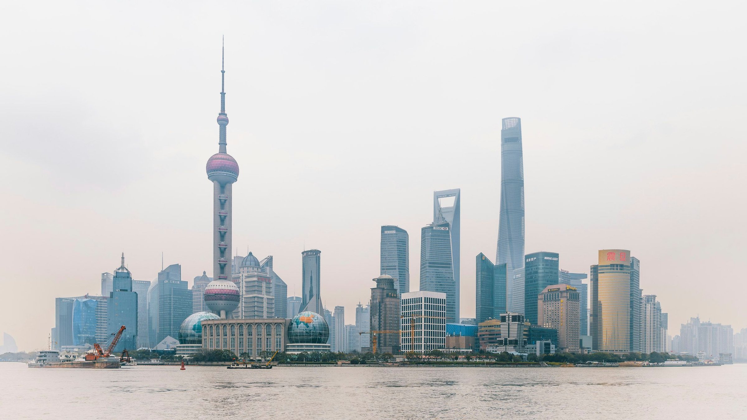 Cakrawala gedung pencakar langit Shanghai di The Bund dengan Menara Oriental Pearl di tepi Sungai Huangpu