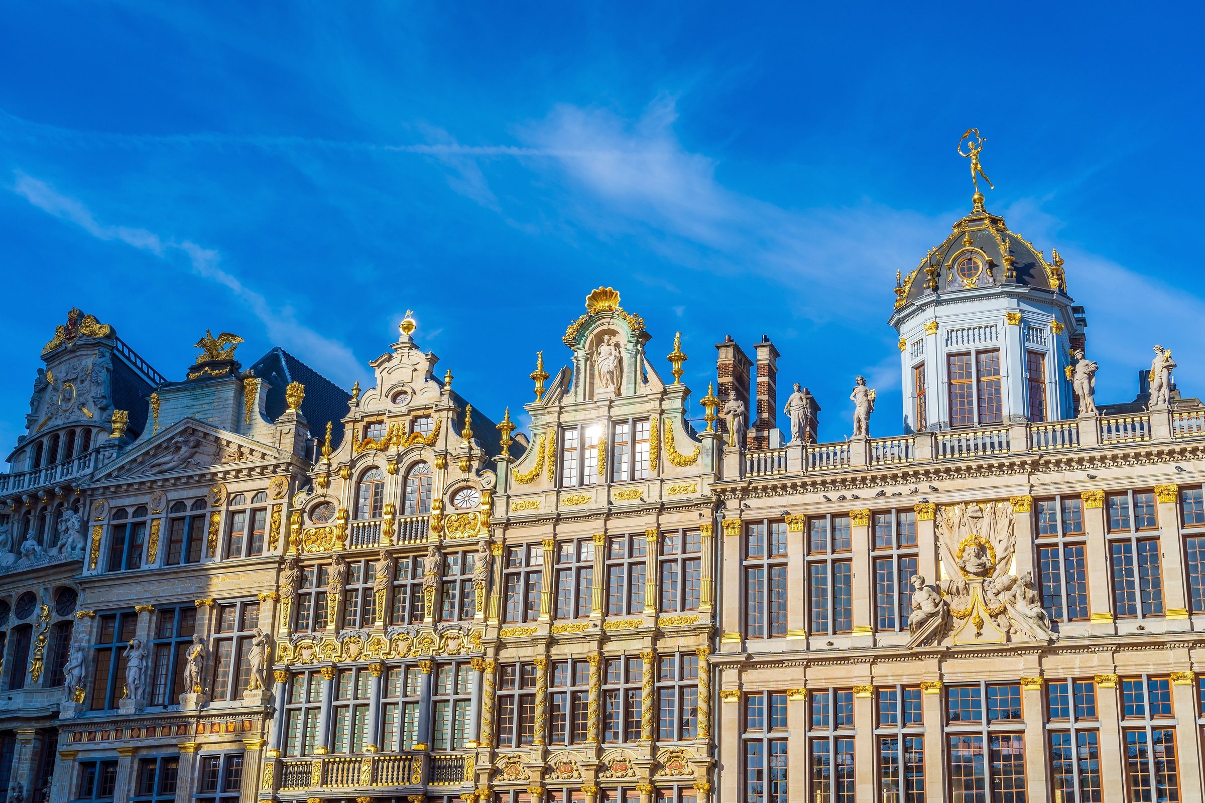 Gedung guild berhias emas di Grand Place Brussels berlatar langit biru pekat