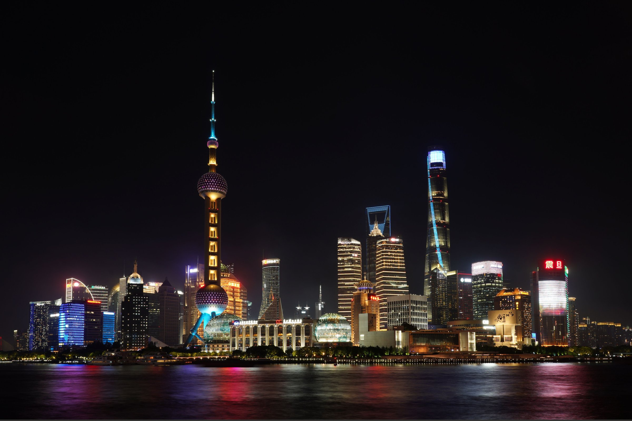 Skyline Pudong Shanghai menyala di malam hari dengan Oriental Pearl Tower dan Sungai Huangpu