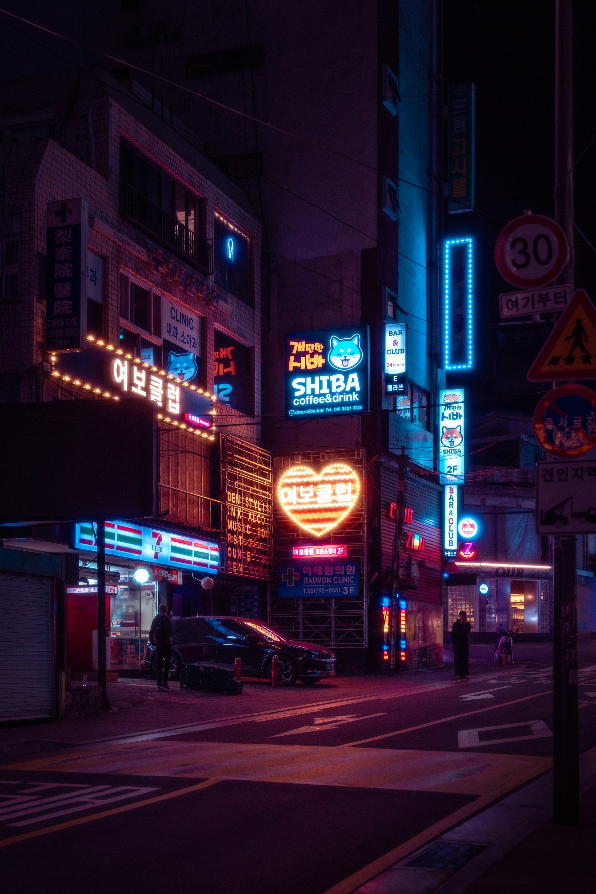 Jalan malam Itaewon Seoul dengan neon-neon toko dan klub berwarna-warni, suasana distrik internasional yang hidup