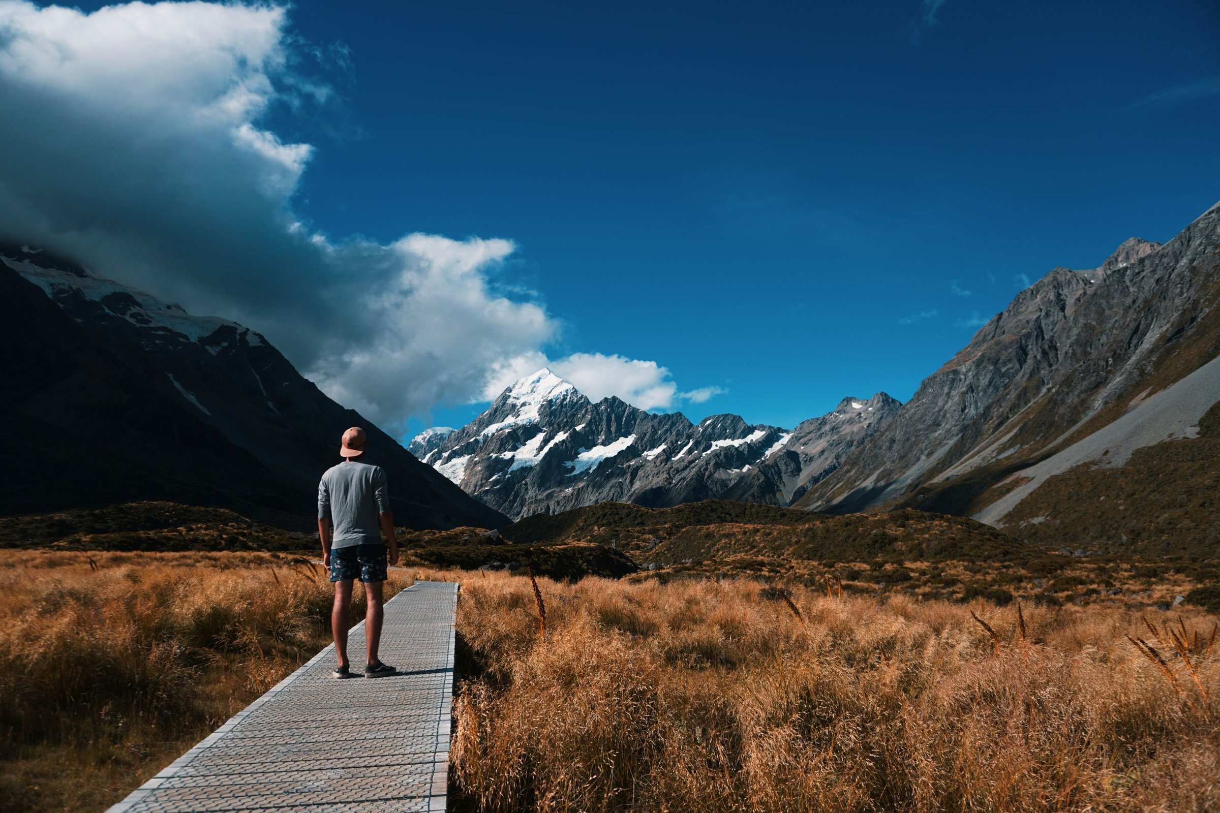 Dinda & Reza: Duduk di batu pinggir Hooker Valley Track sambil lihat Aoraki dari kejauhan