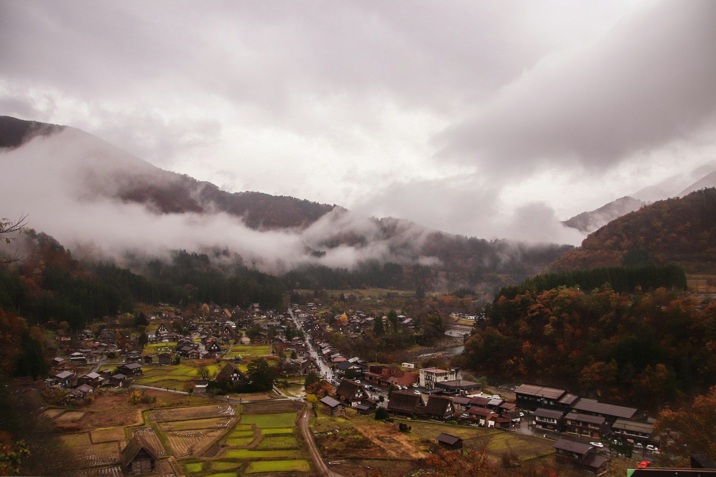 Desa Shirakawago dari atas, rumah gassho-zukuri tersebar di lembah dengan pepohonan musim gugur oranye