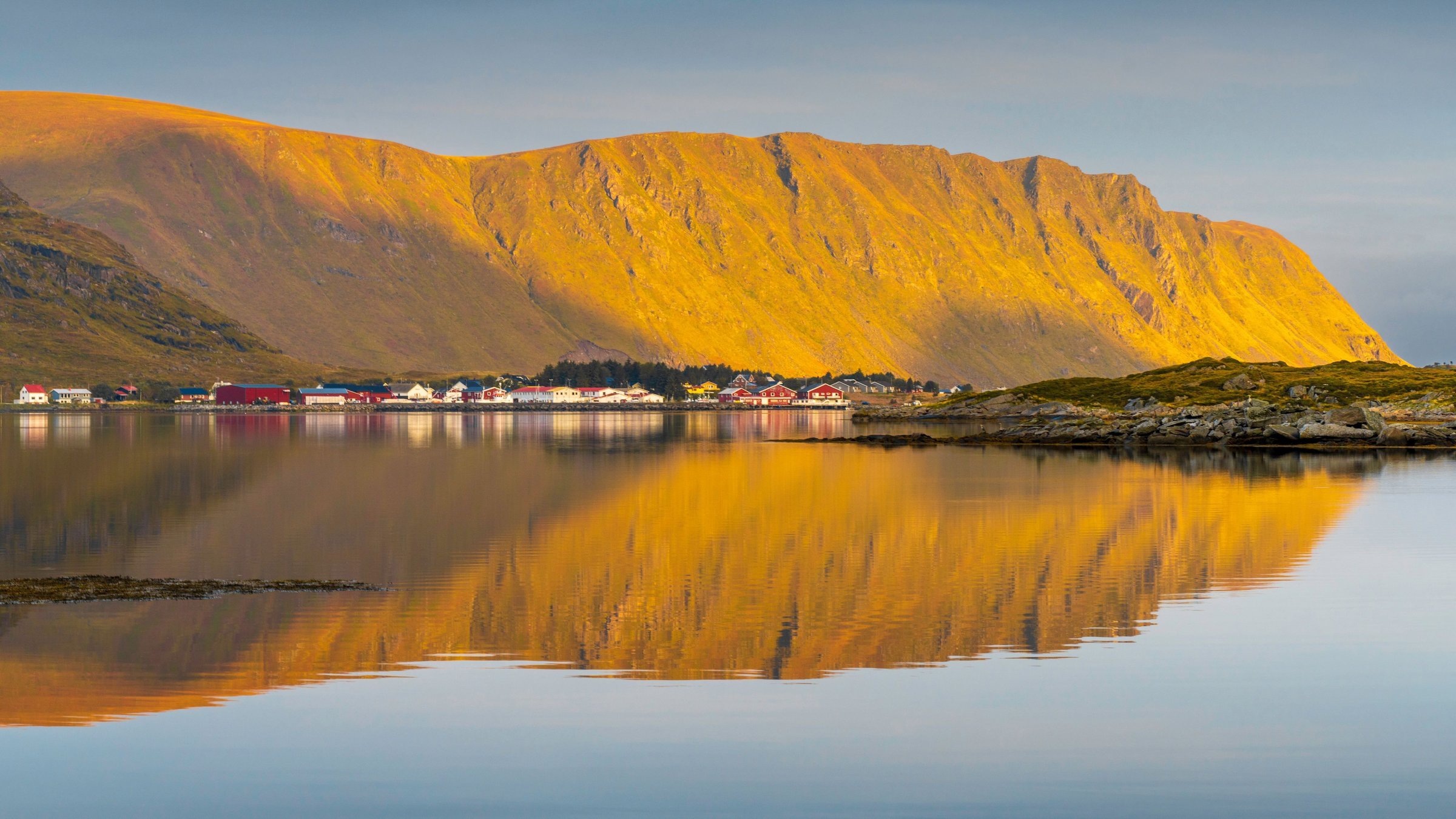 Fjord Norwegia dengan tebing curam dan air tenang di kaki pegunungan.