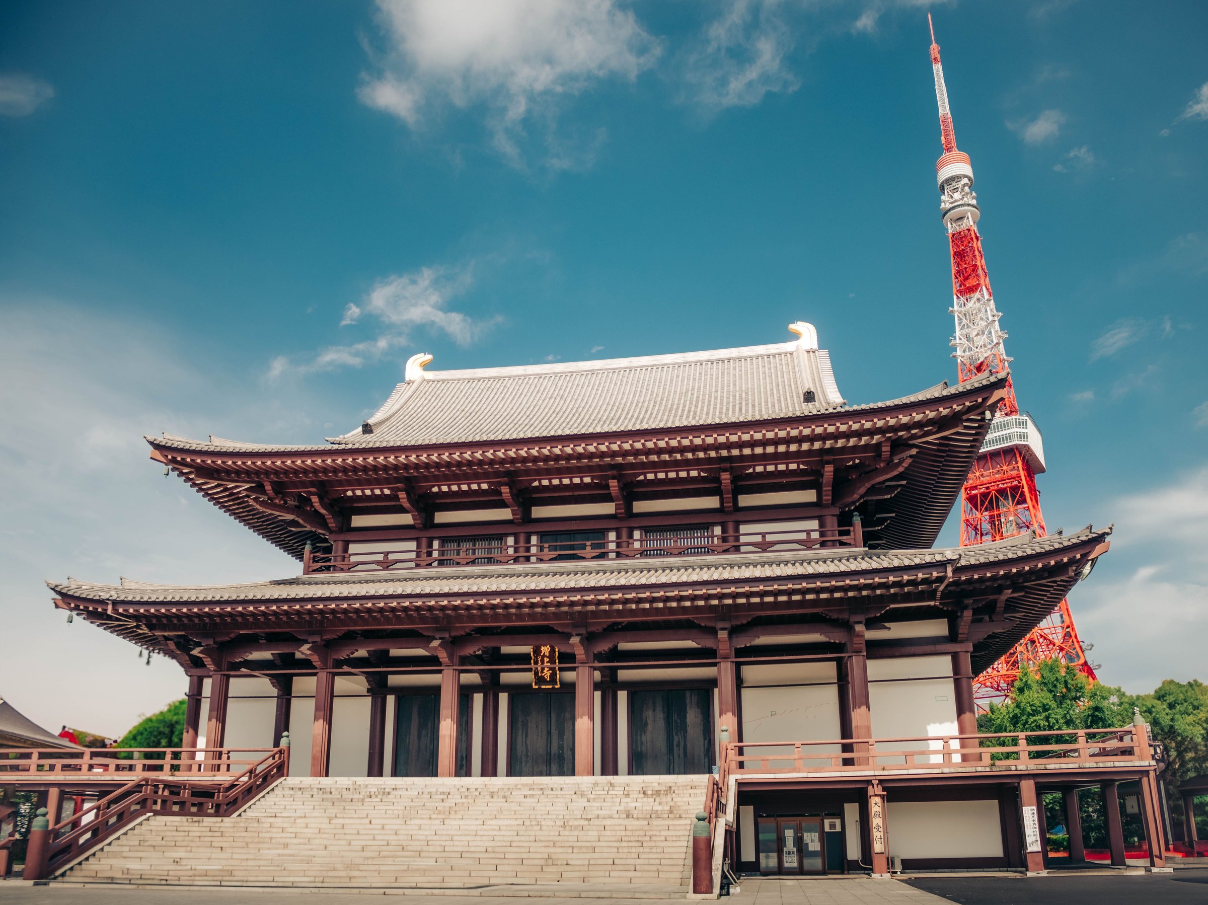 Tokyo Tower menjulang di belakang Kuil Zojoji dengan langit biru cerah