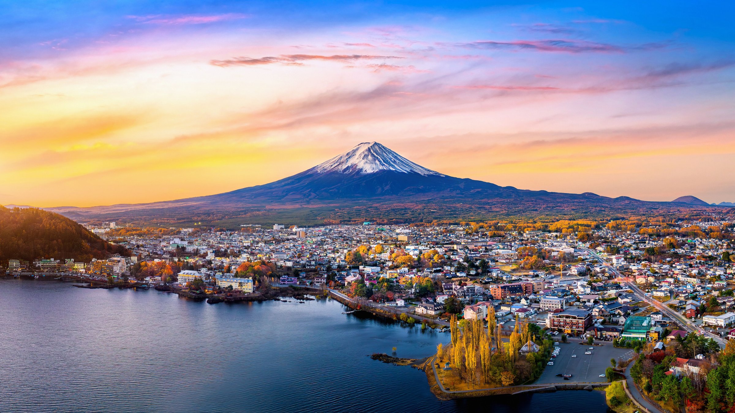 Gunung Fuji di atas Danau Kawaguchi dengan kota dan pepohonan musim gugur saat senja