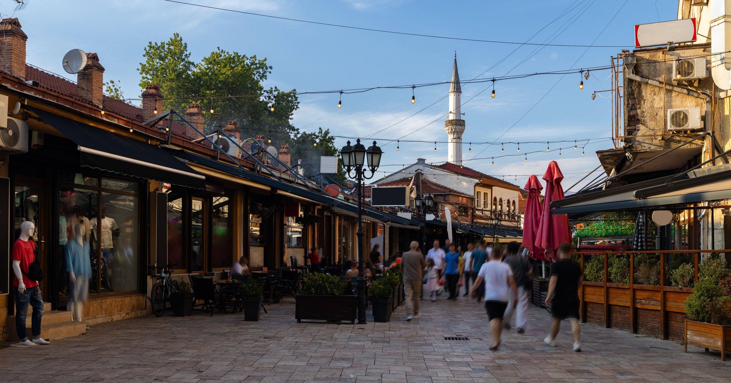 Kawasan Bazaar Tua Skopje dengan deretan kafe, lampu gantung, dan menara masjid