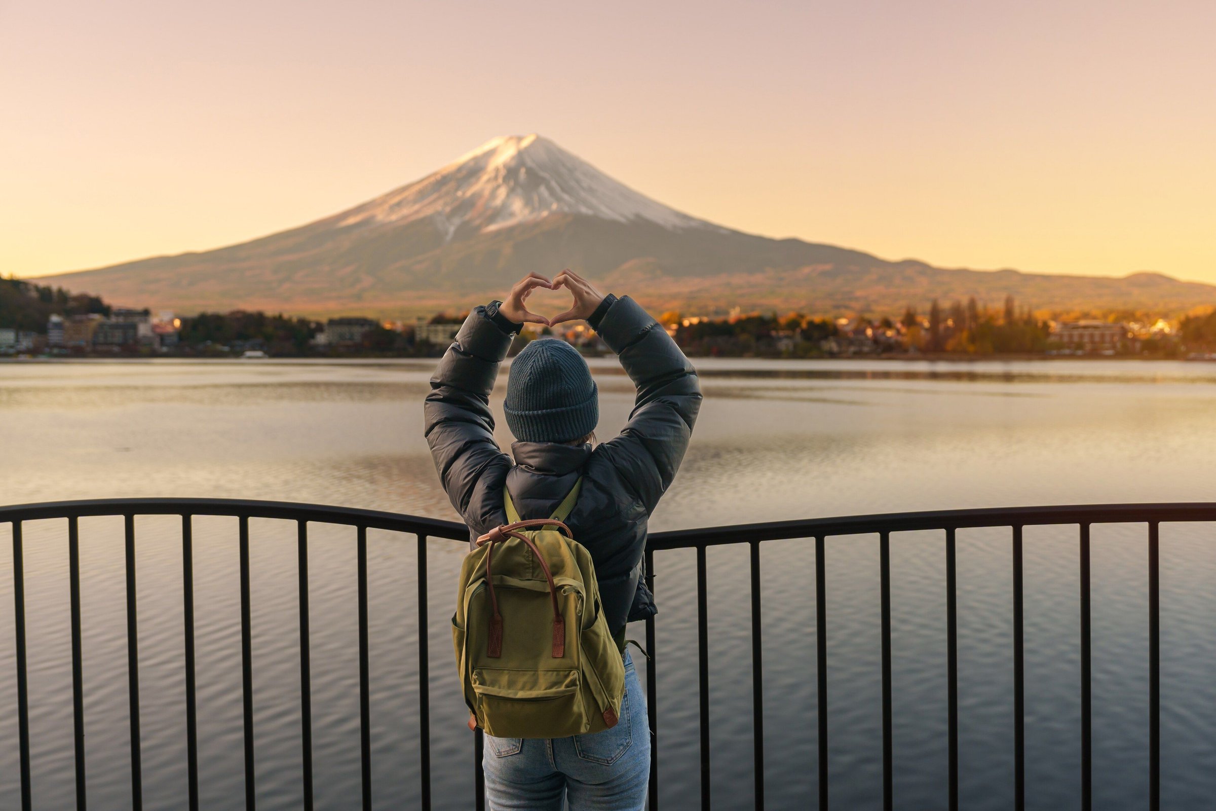 Wisatawan membentuk hati dengan tangan di depan Gunung Fuji dan Danau Kawaguchi saat matahari terbenam