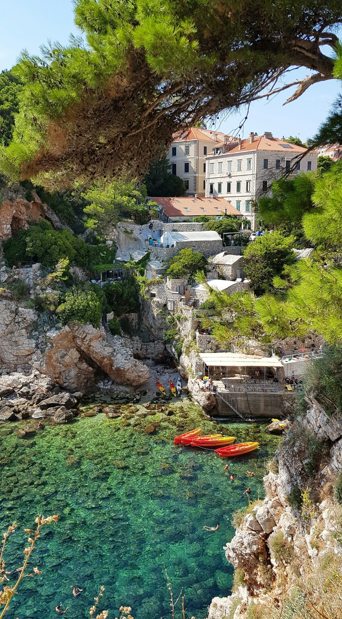 Garis pantai Adriatik Dubrovnik dengan air biru jernih dan dinding batu kuno