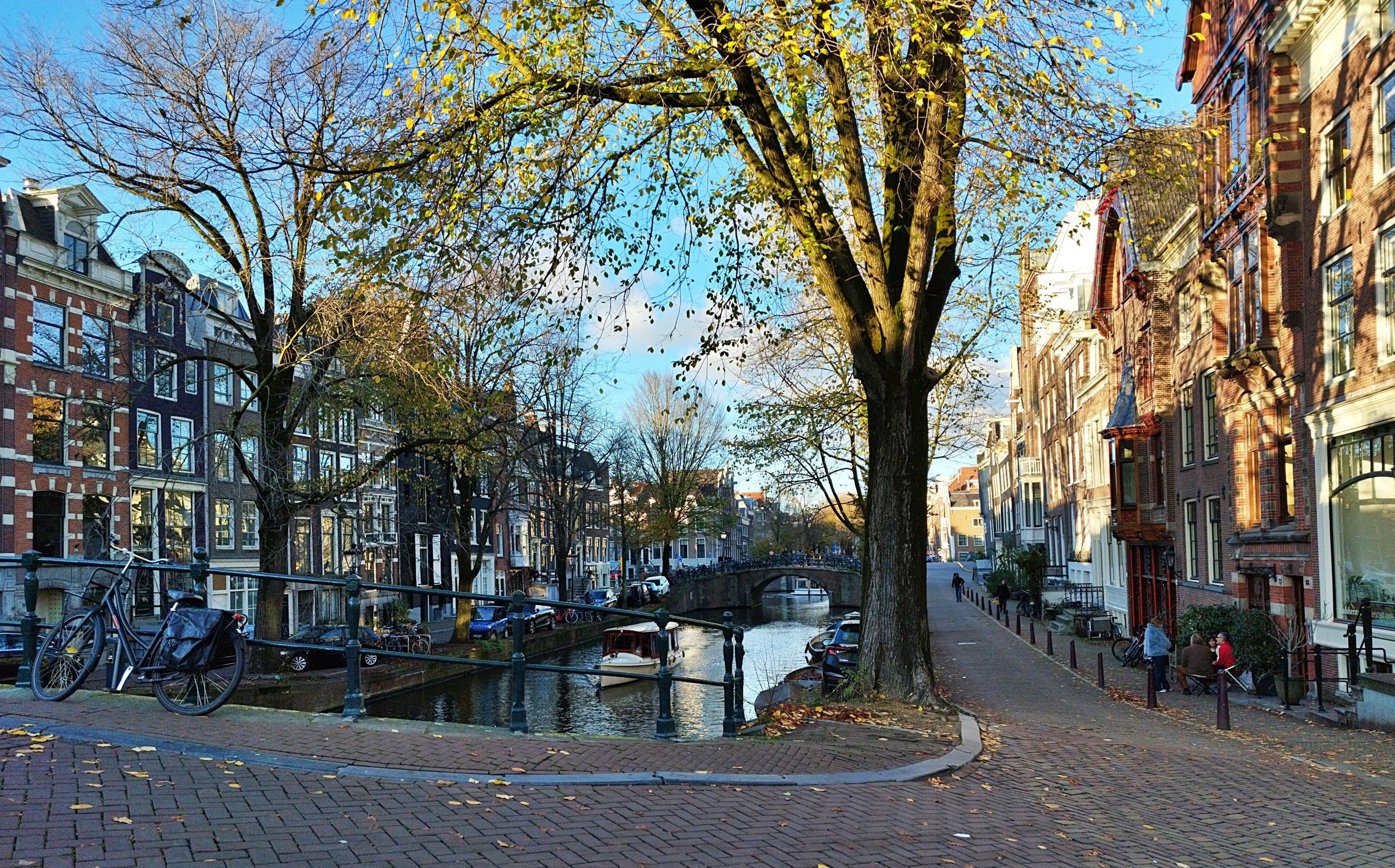 Kanal Amsterdam dengan deretan rumah sempit dan pepohonan musim gugur.