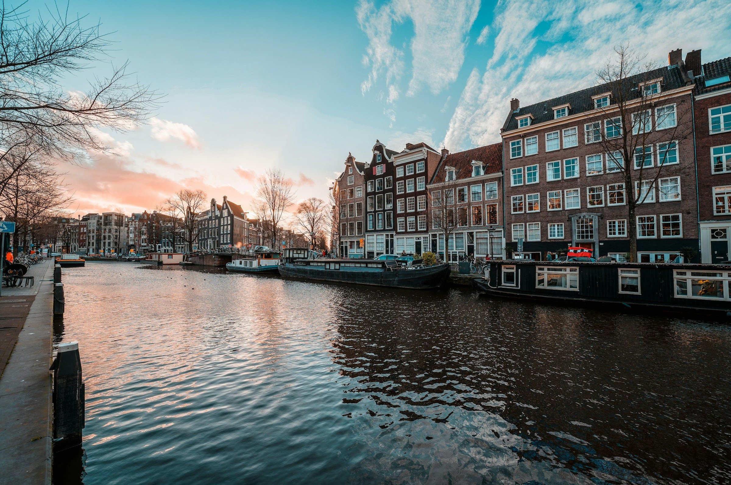 Kanal Amsterdam dengan rumah bergaya gable klasik saat senja