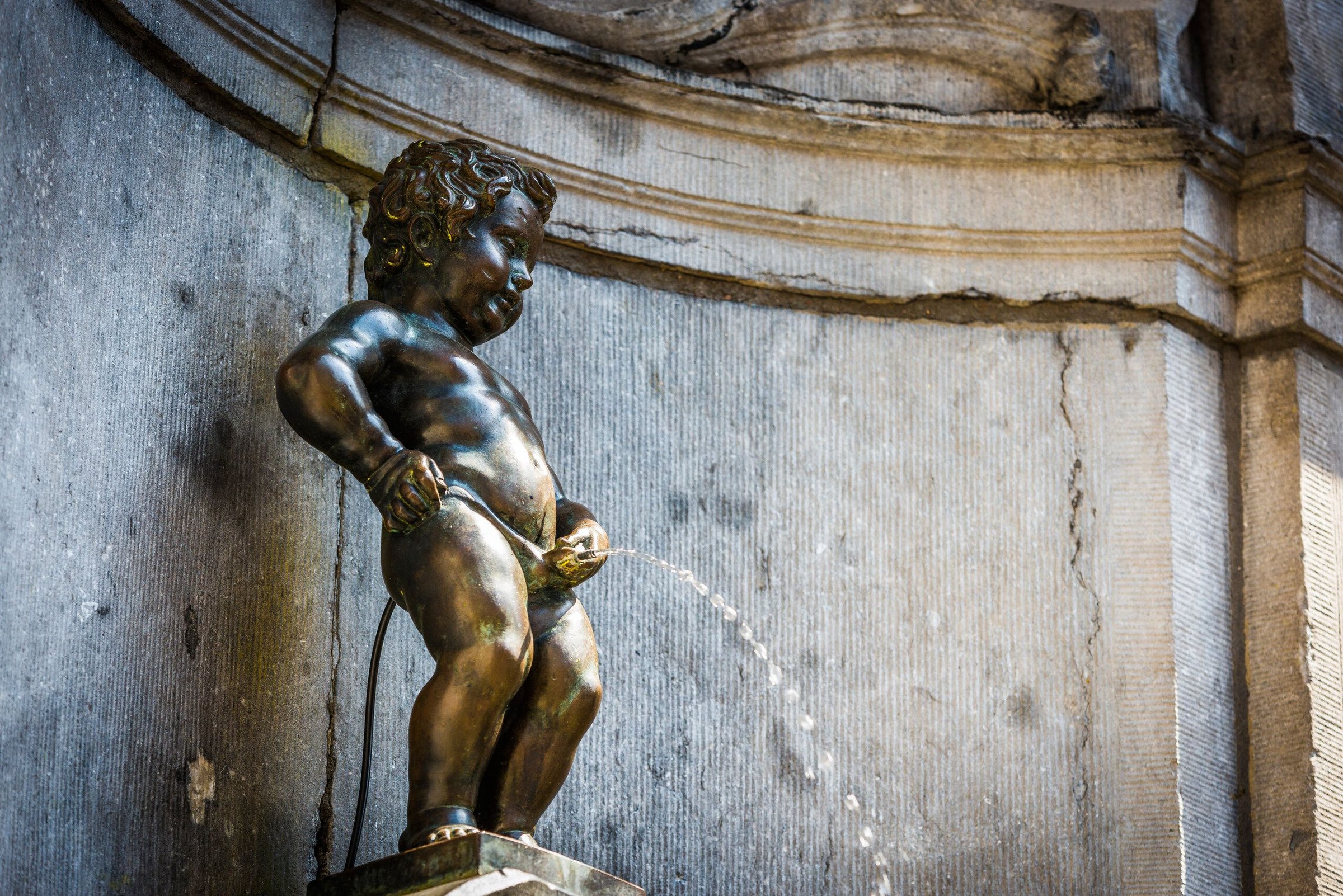Patung perunggu Manneken Pis di Brussels yang mengalirkan air.